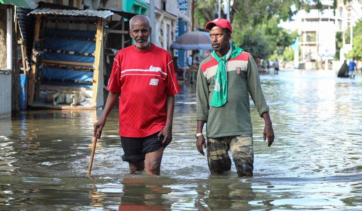 Warga berjalan di tengah banjir yang merendam wilayah Somalia.
