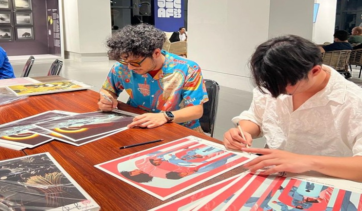 Kunto Aji dan Antonio Reinhard menandatangani seni lukis kolaborasi mereka.