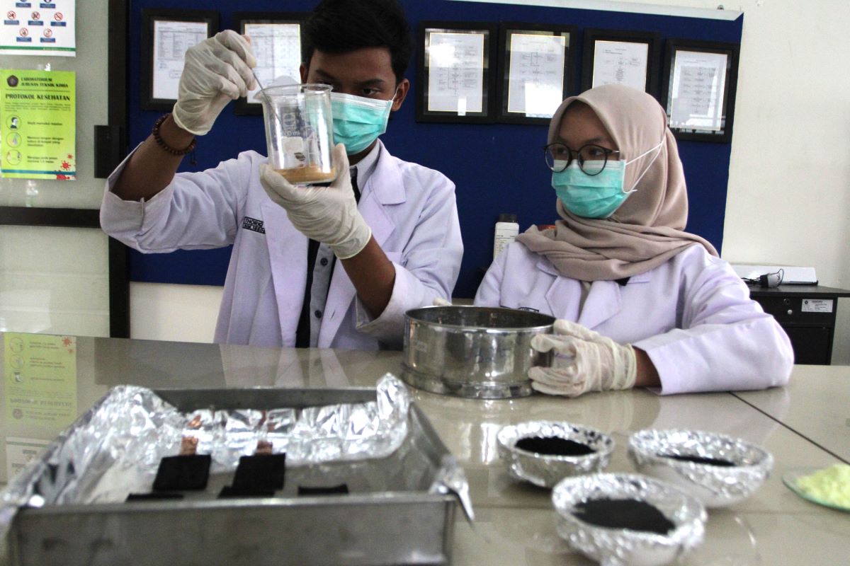 Pelajar melakukan praktik dengan bahan kimia.