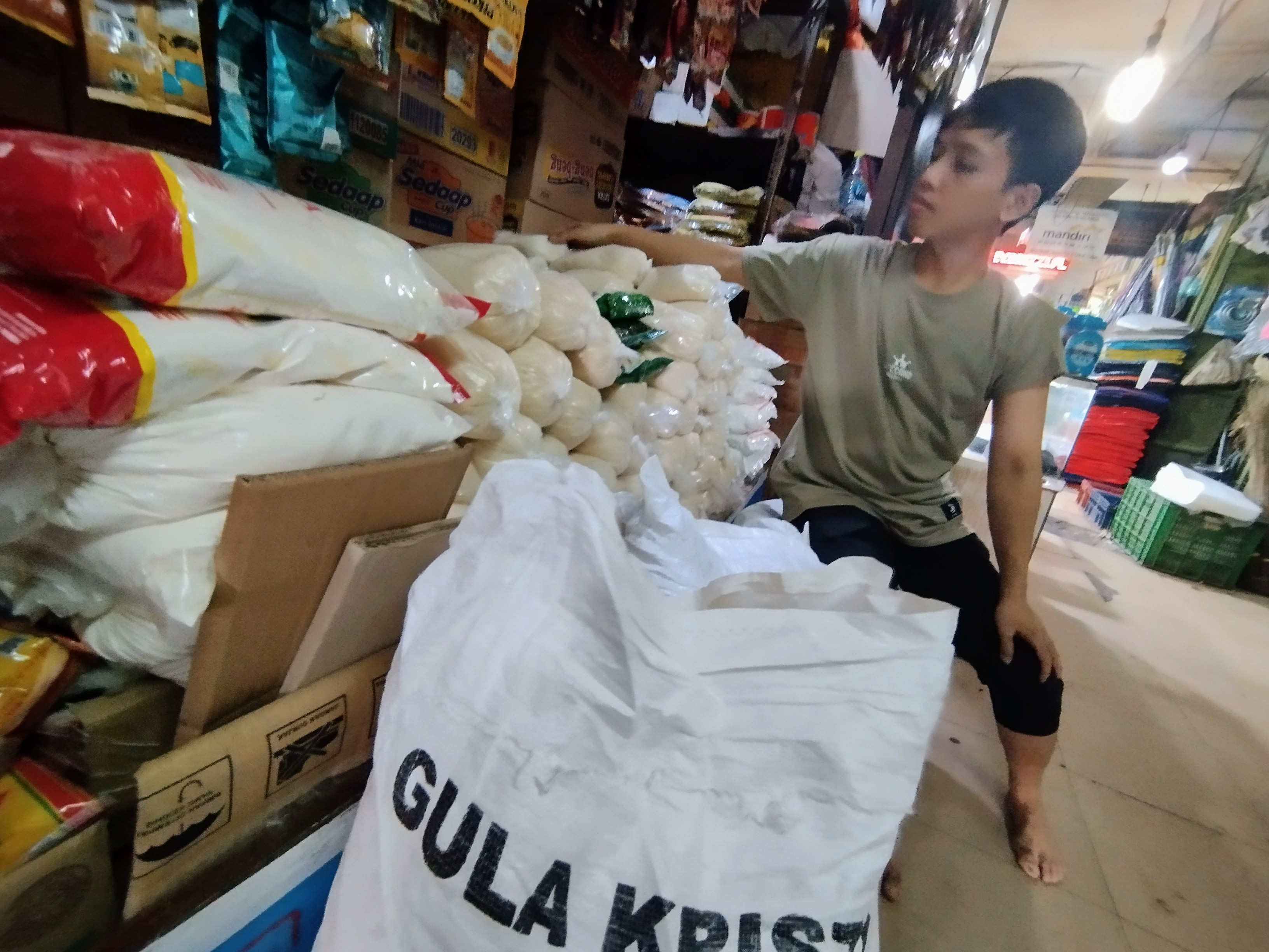 Pedagang menata gula pasir kemasan