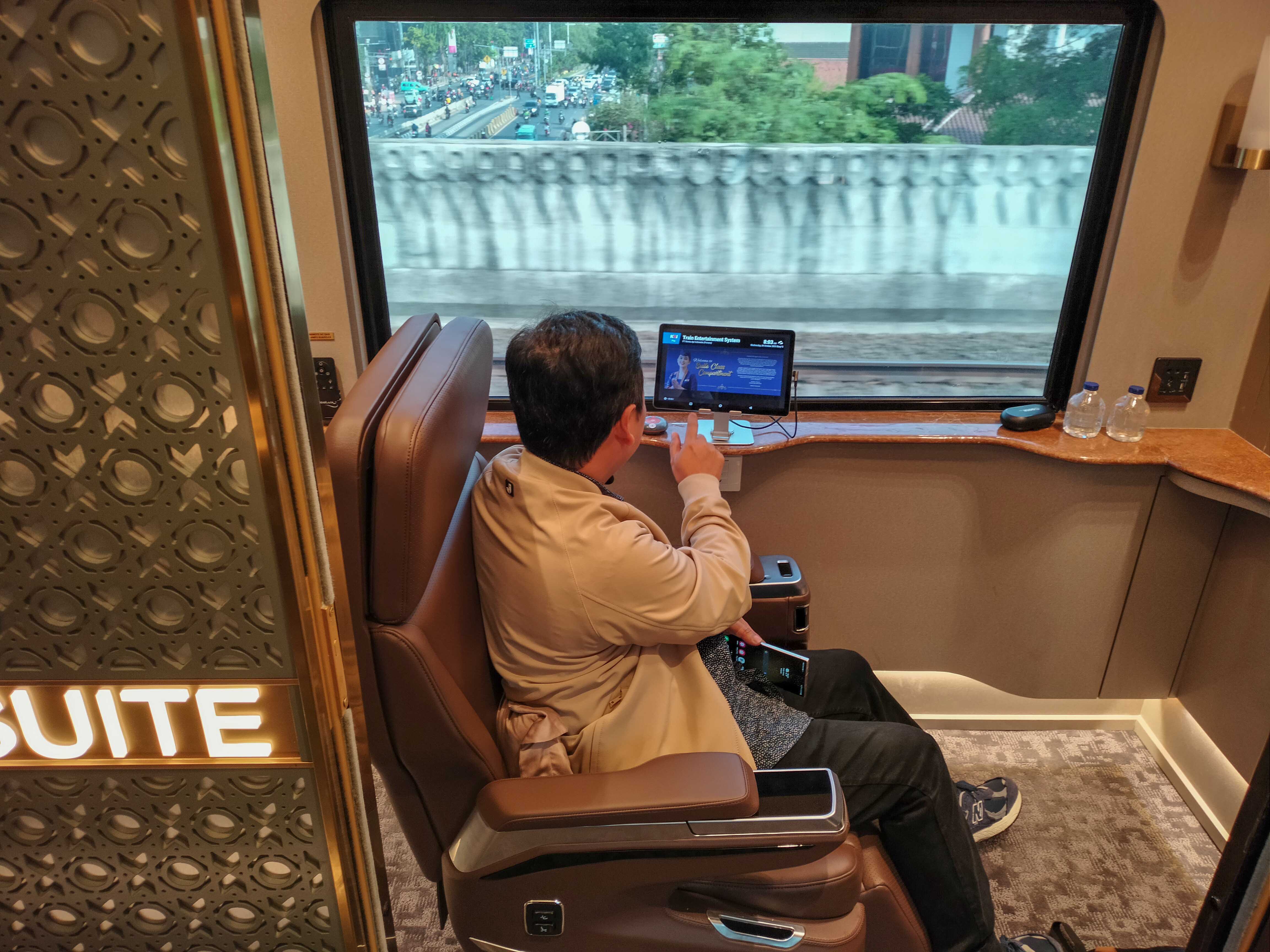 Seorang penumpang menikmati perjalanan dengan kereta api