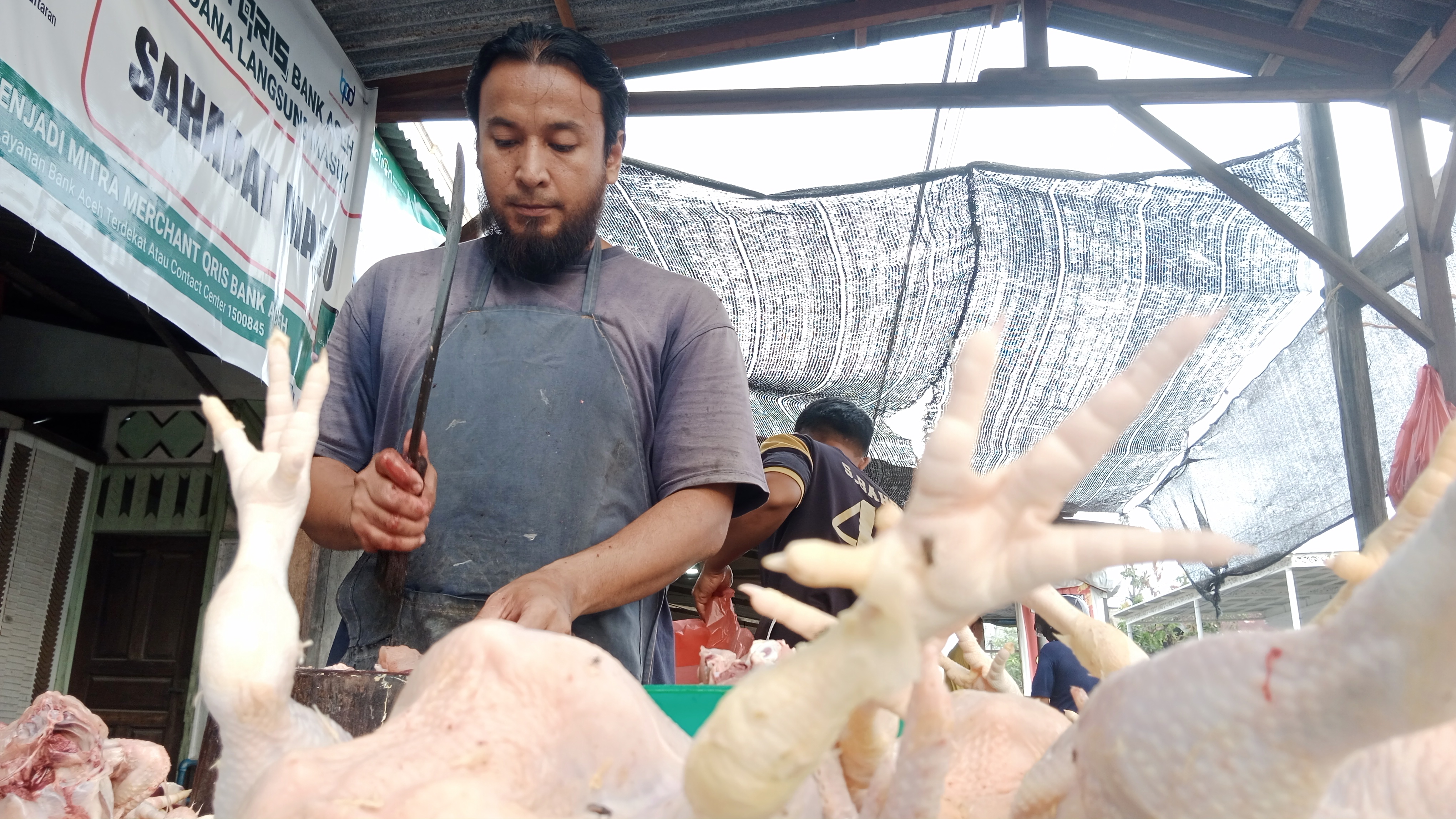 Pedagang memotong daging ayam di pasar