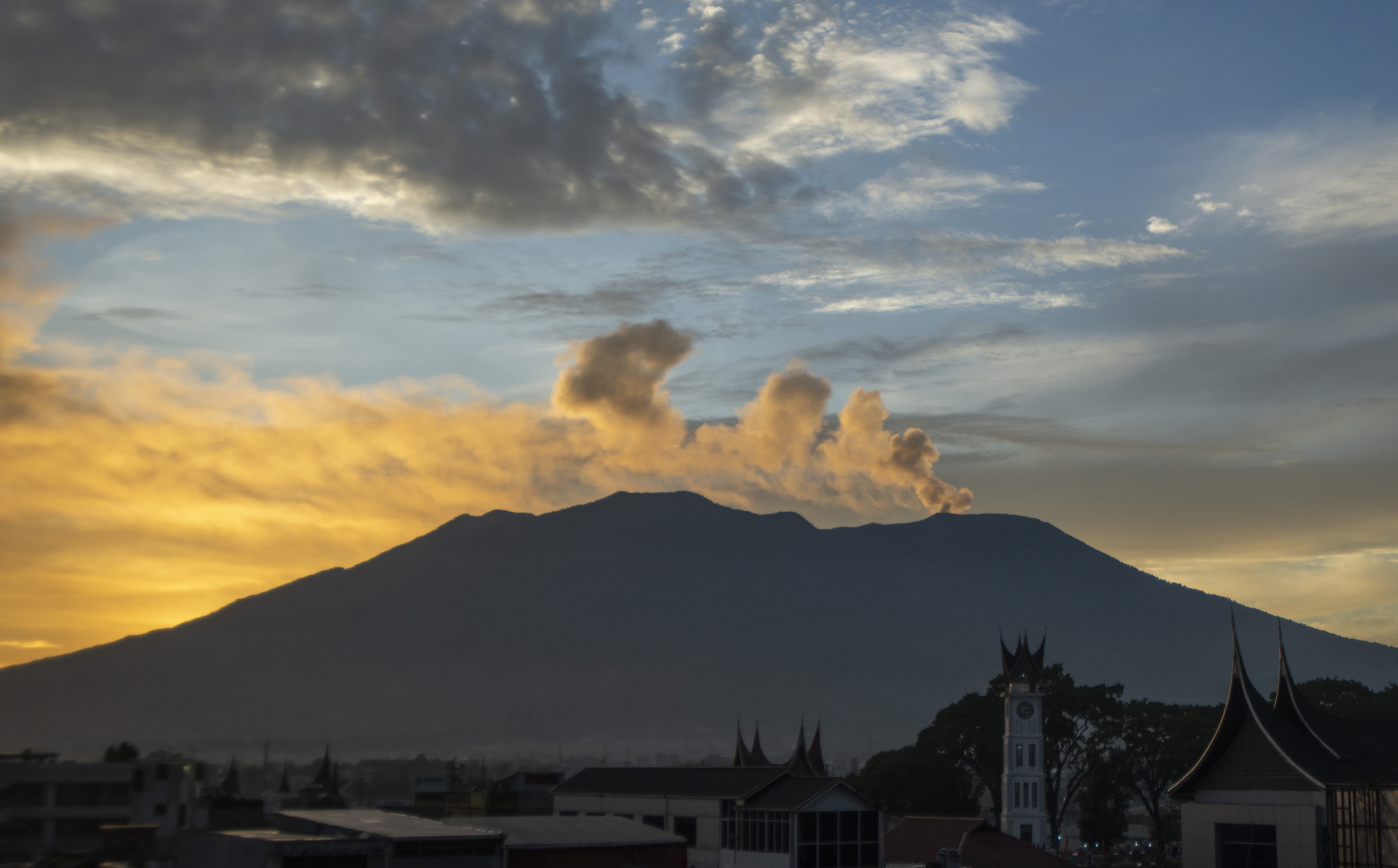 Gunung Marapi mengeluarkan abu vulkanik saat matahari terbit, terlihat dari Kota Bukittinggi, Sumatera Barat, Jumat (8/12).