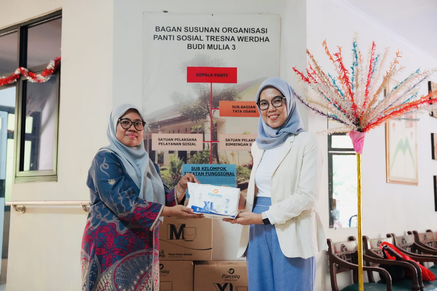 Parenty mendonasikan popok bagi perempuan lansia ke panti jompo di Jabodetabek, Jumat (22/12).