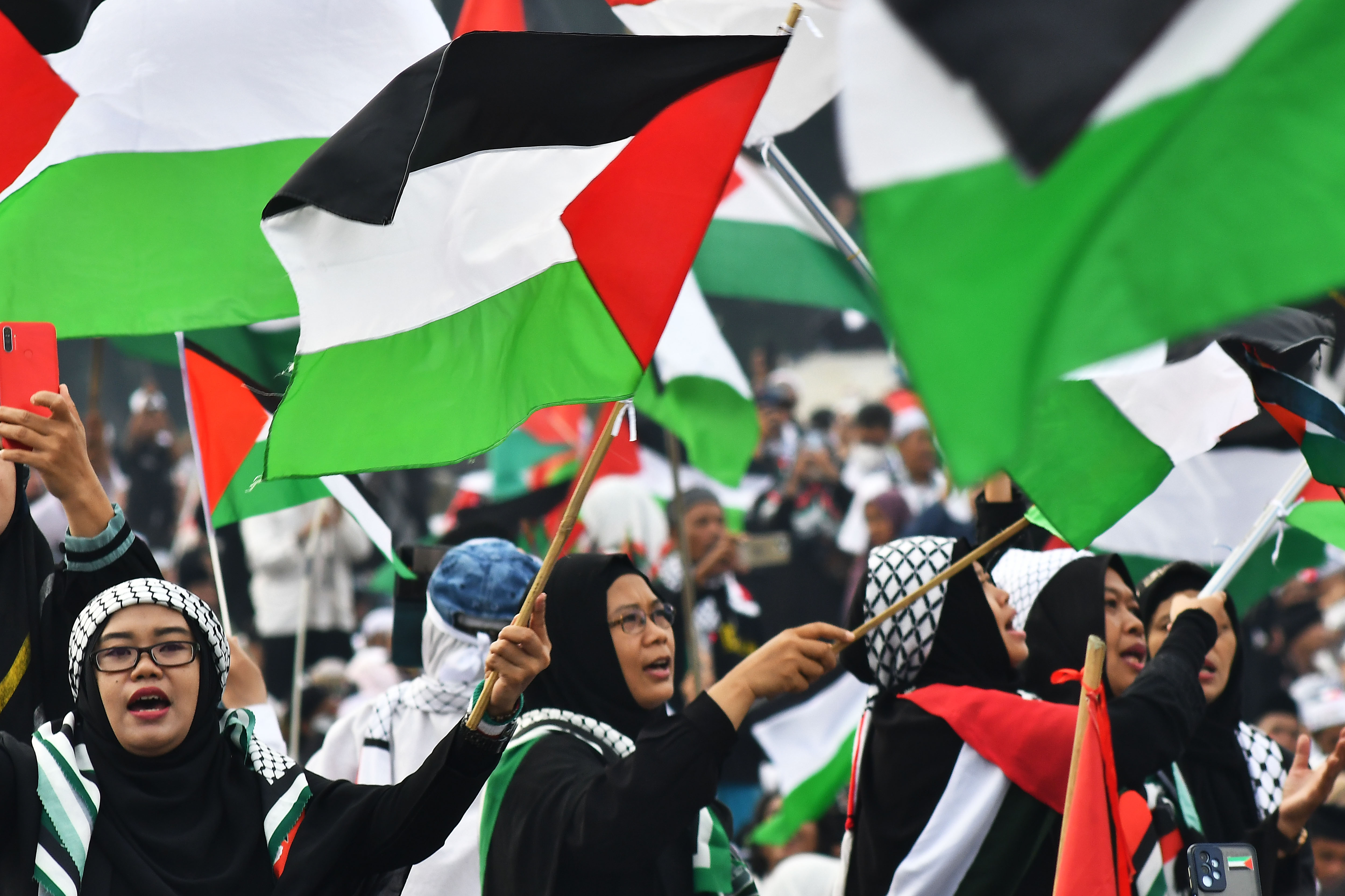 Sejumlah warga mengibarkan bendera Palestina