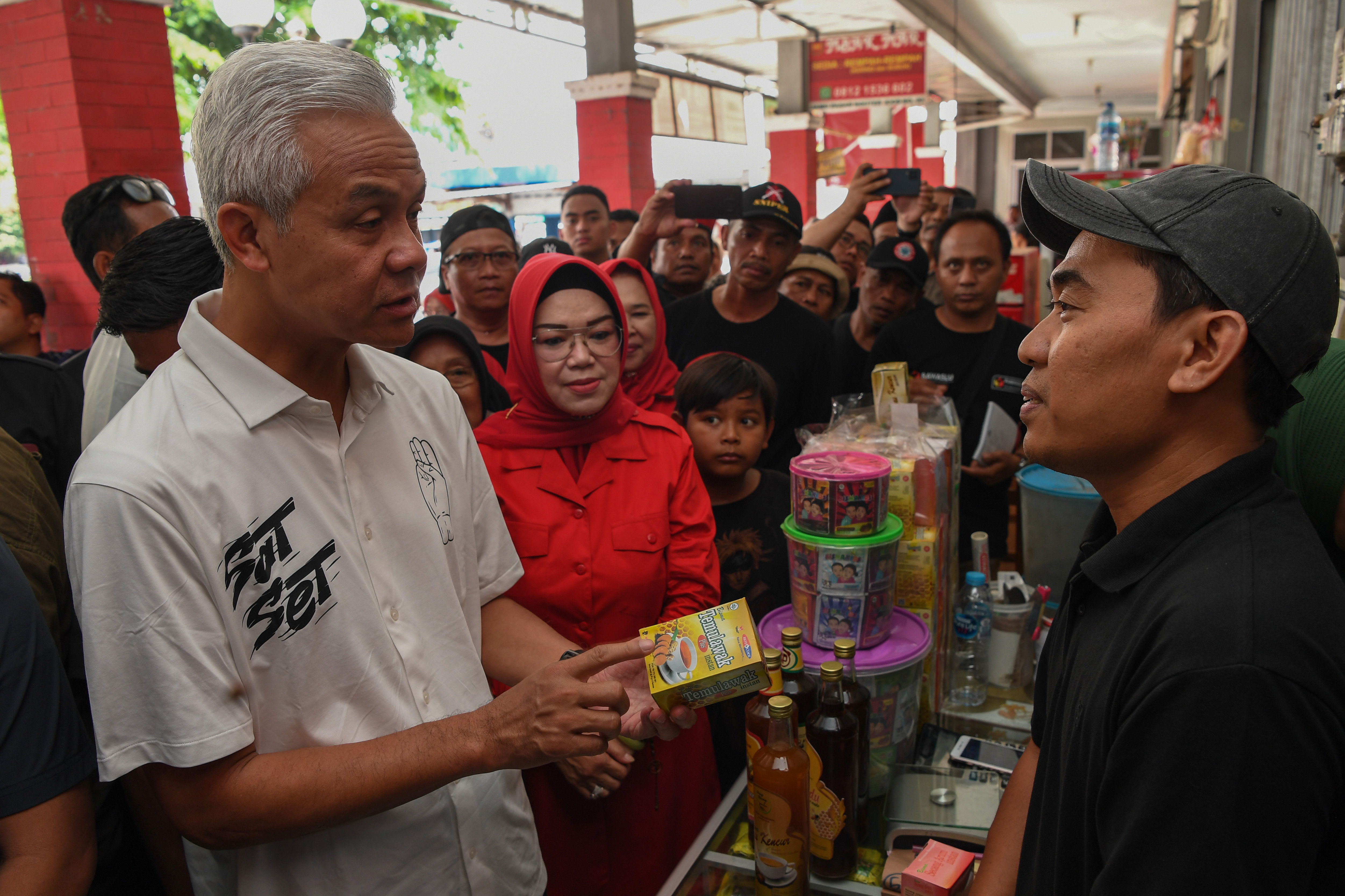 Ganjar Pranowo (kiri) berdialog dengan pedagang jamu saat blusukan ke Pasar Jamu Nguter, Sukoharjo