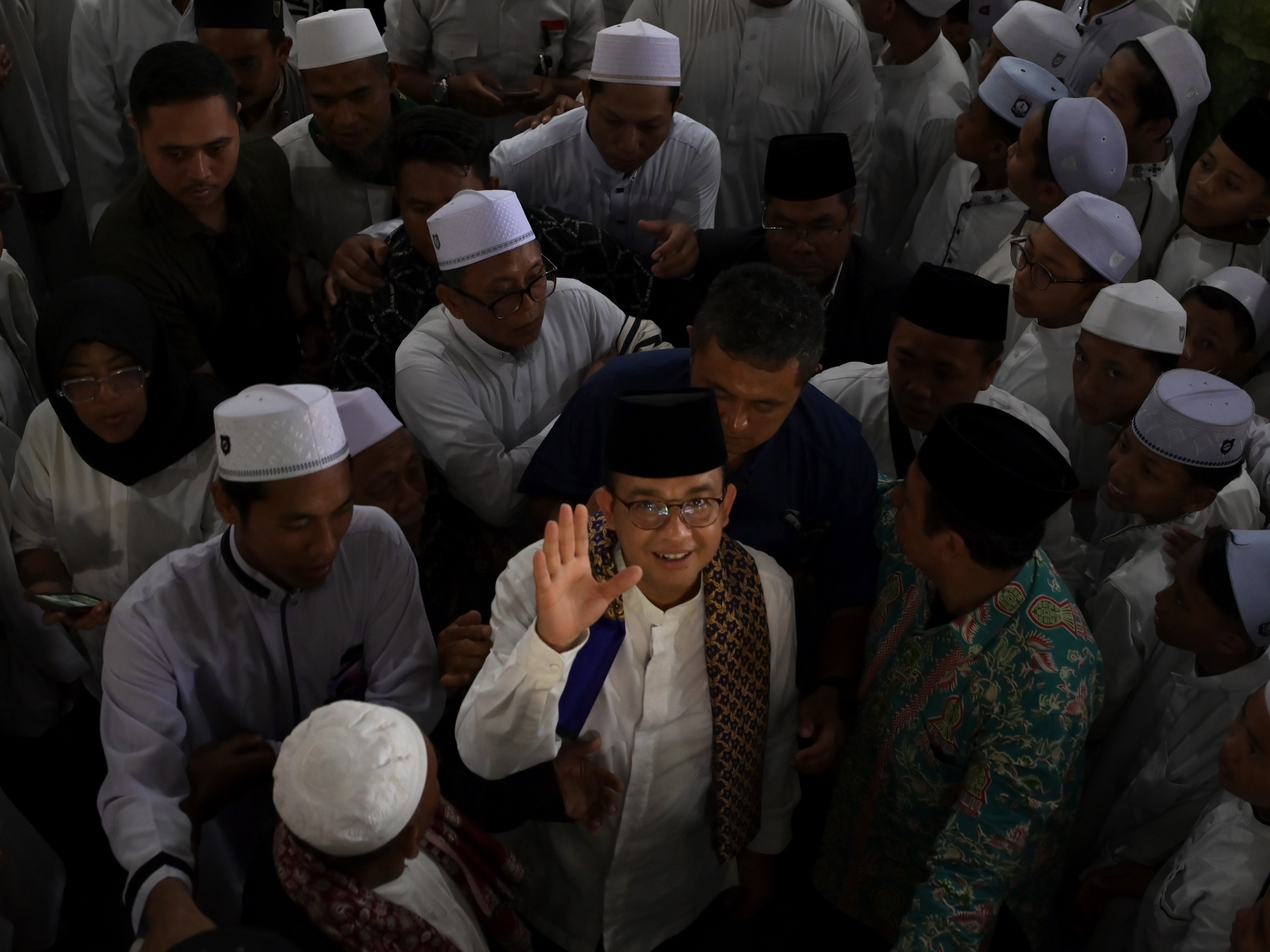 Calon presiden nomor urut 1 Anies Baswedan (tengah) mengangkat tangannya usai berkampanye di Ponpes Al-Aziziyah Kapek, Kecamatan Gunungsari.