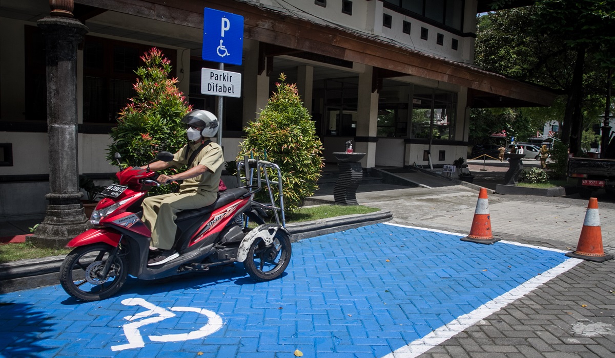 Pegawai Balai Kota memarkir motornya di tempat parkir khusus difabel Balai Kota, Solo, Jawa Tengah