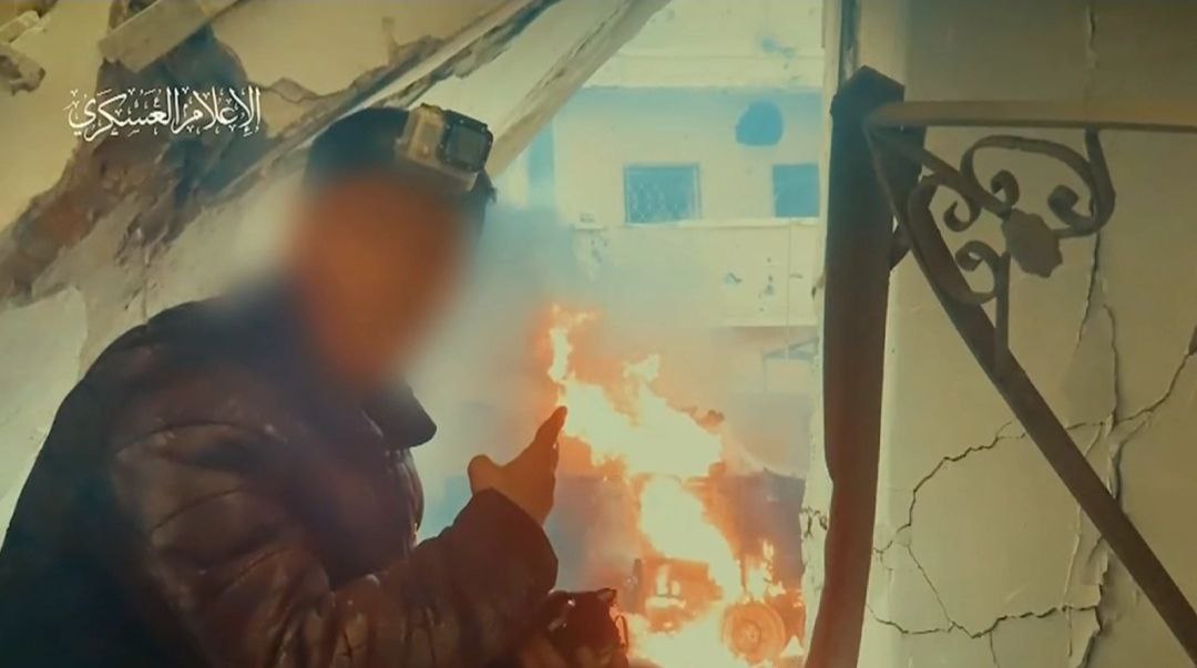 Anggota Brigade Al-Qassam menunjukkan salah satu tank Israel yang berhasil diledakkan.