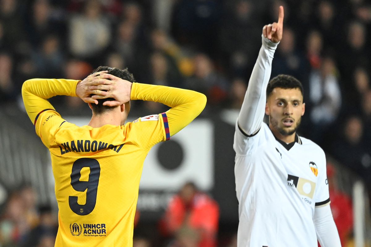 Robert Lewandowski berhadapan dengan pemain Valencia Selim Amallah.