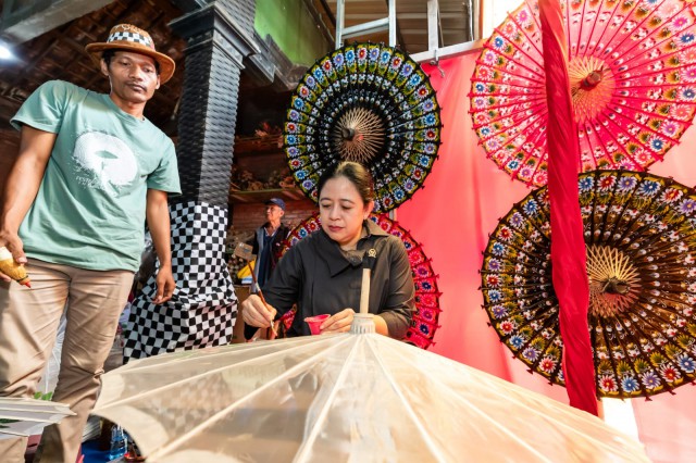 Ketua DPR RI Puan Maharani saat mencoba melukis payung saat mengujungi kindustri kreatif Payung Lukis Ngudi Rahayu di Klaten, Senin (4/12).