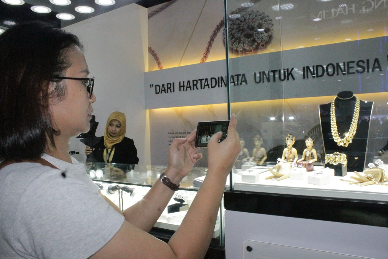 Pengunjung sedang mengambil gambar perhiatan di gerai Hartadinata.