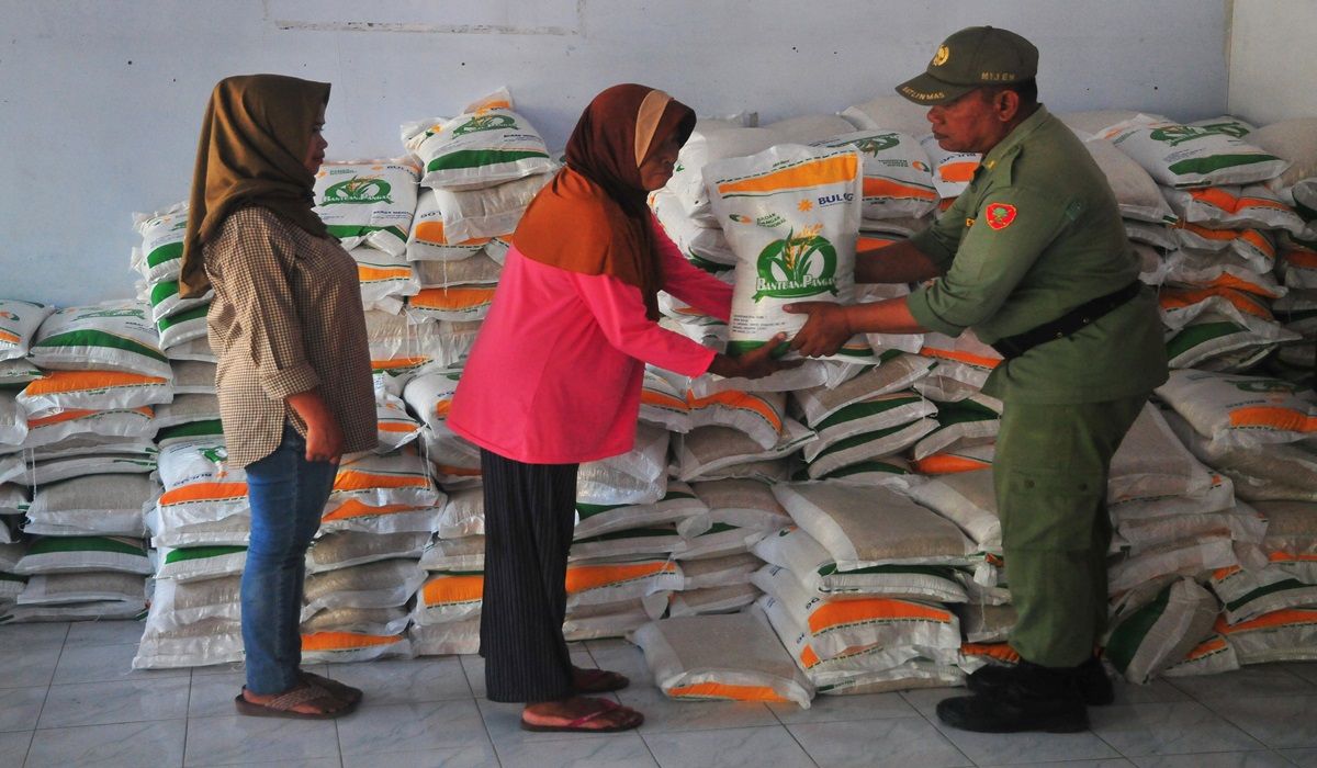 Warga menerima beras saat penyaluran bantuan pangan cadangan beras pemerintah