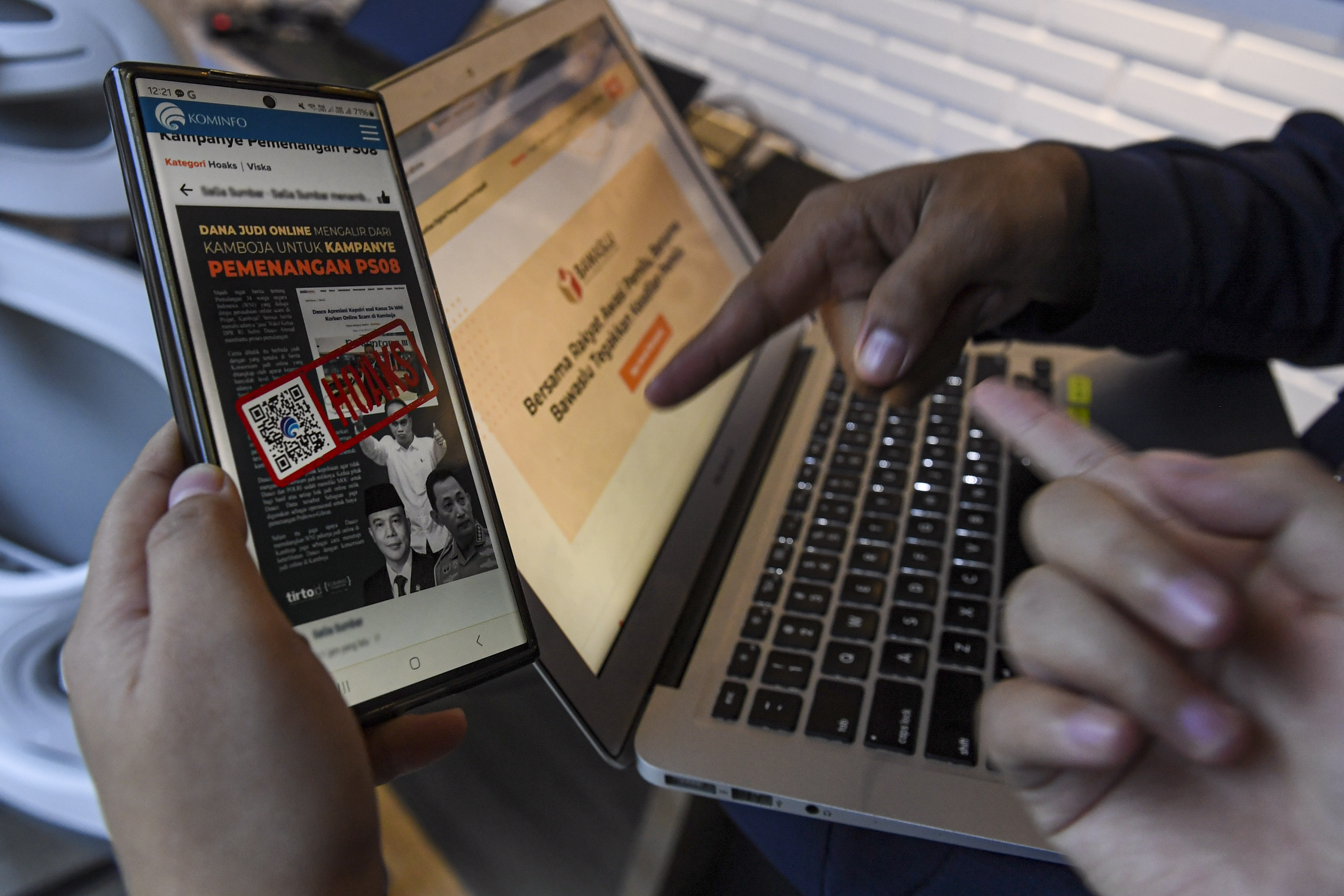 Warga melihat aplikasi pengawasan pelaksanaan Pemilu 2024. Aplikasi ini untuk mencegah serta menyaring berita bohong (hoax).  