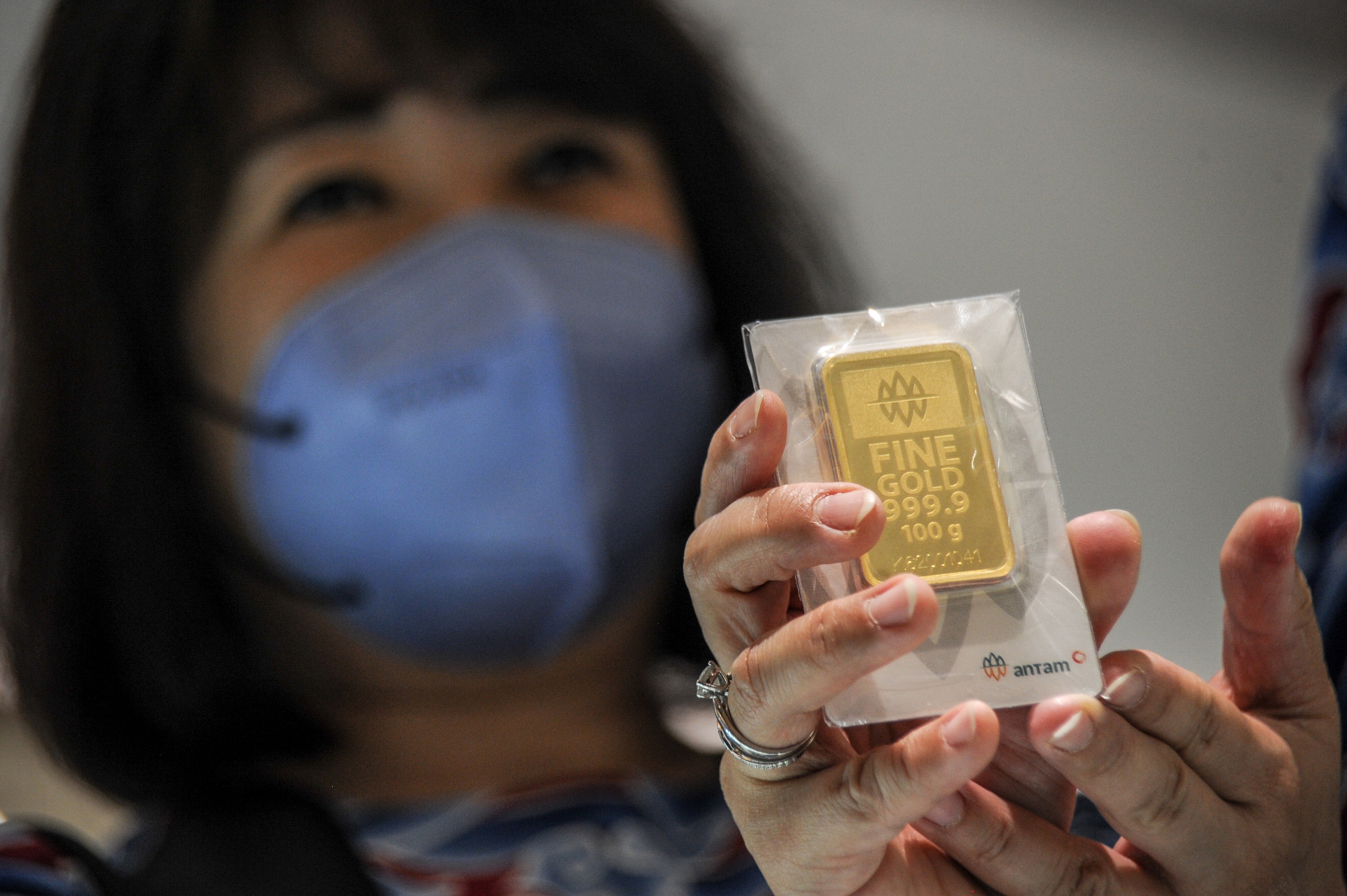 Direktur PT Hartadinata Abadi Sandra Sunanto menunjukkan emas murni 100 gram di gerai emas Hartadinata Abadi di Bandung, Jawa Barat.