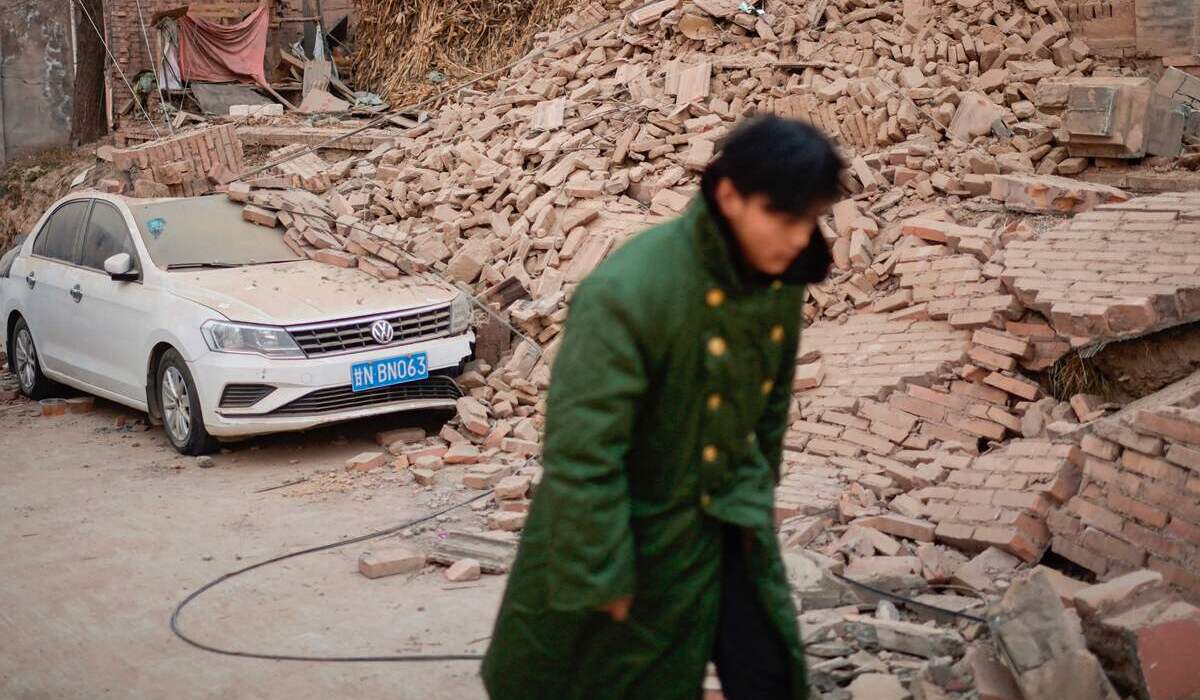 Warga Gansu, Tiongkok, berjalan di antara reruntuhan sisa gempa bumi pada Selasa, 19 Desember 2023.