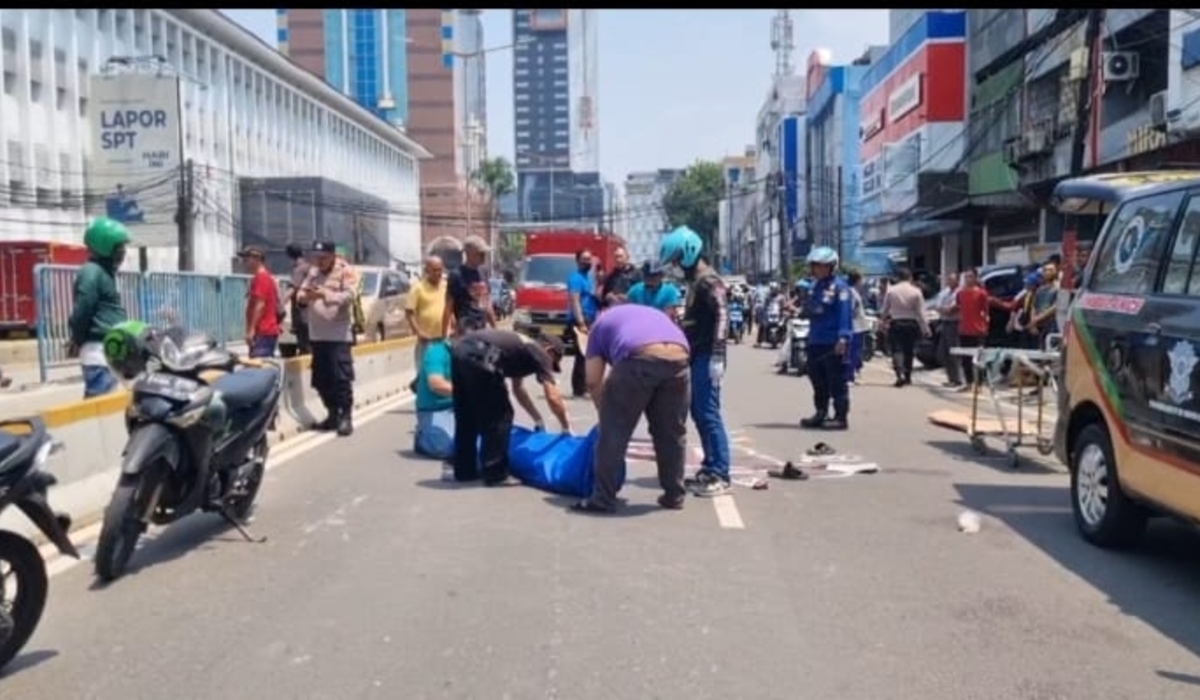 Warga evakuasi pengendara motor yang tewas terlindas truk di Gambir, Jakarta Pusat.