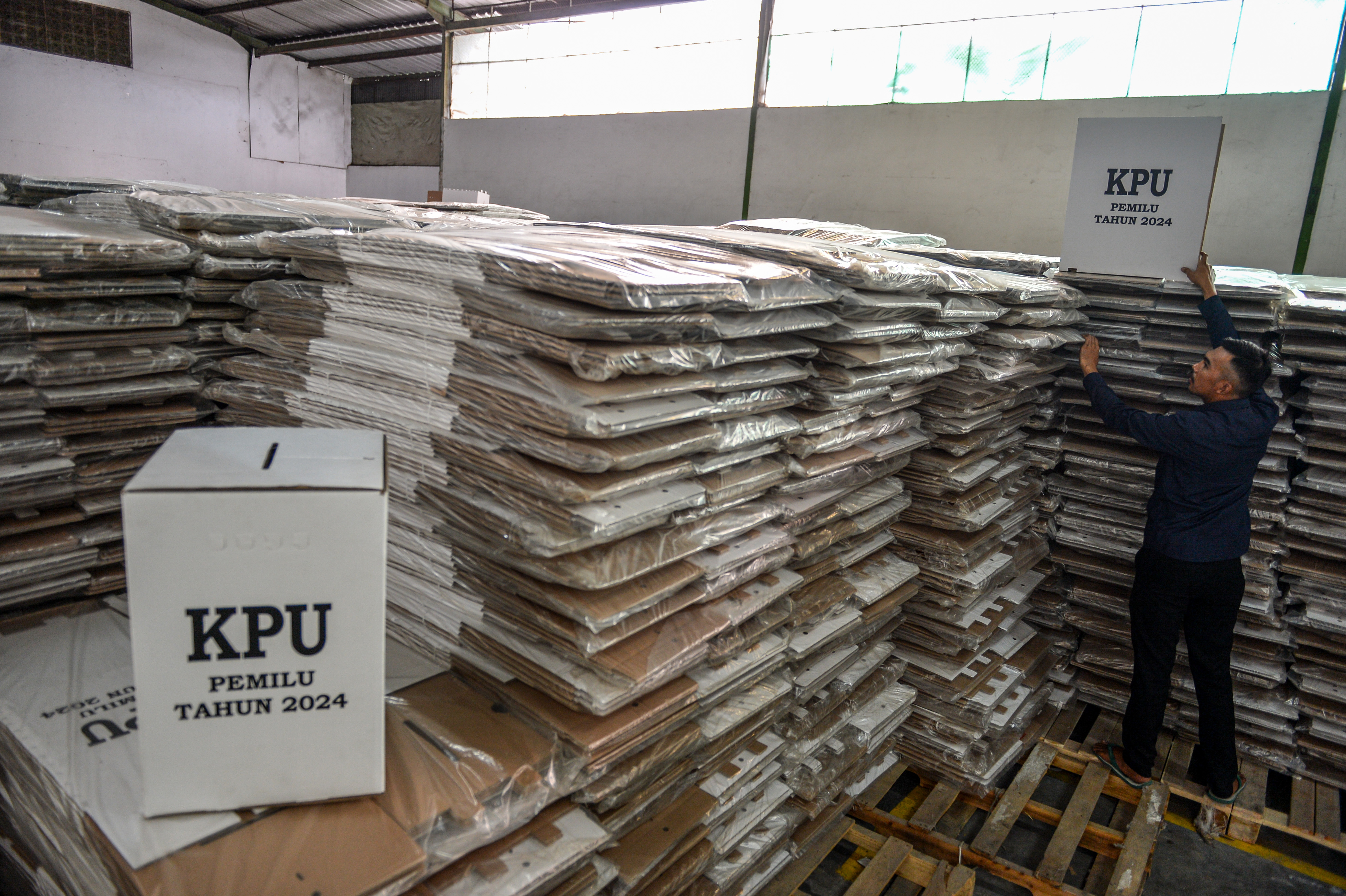Petugas meletakkan contoh bilik suara yang telah dirakit di gudang logistik Pemilu.