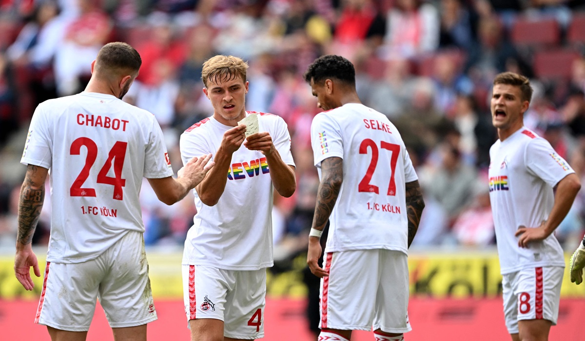 Para pemain Cologne membaca instruksi saat laga Bundesliga.