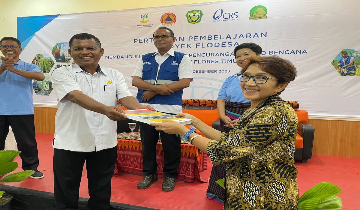 Yenni Suryani, Country Manager CRS Indonesia melakukan serah terima secara simbolis kepada Yoris selaku perwakilan BPBD Flores Timur, 