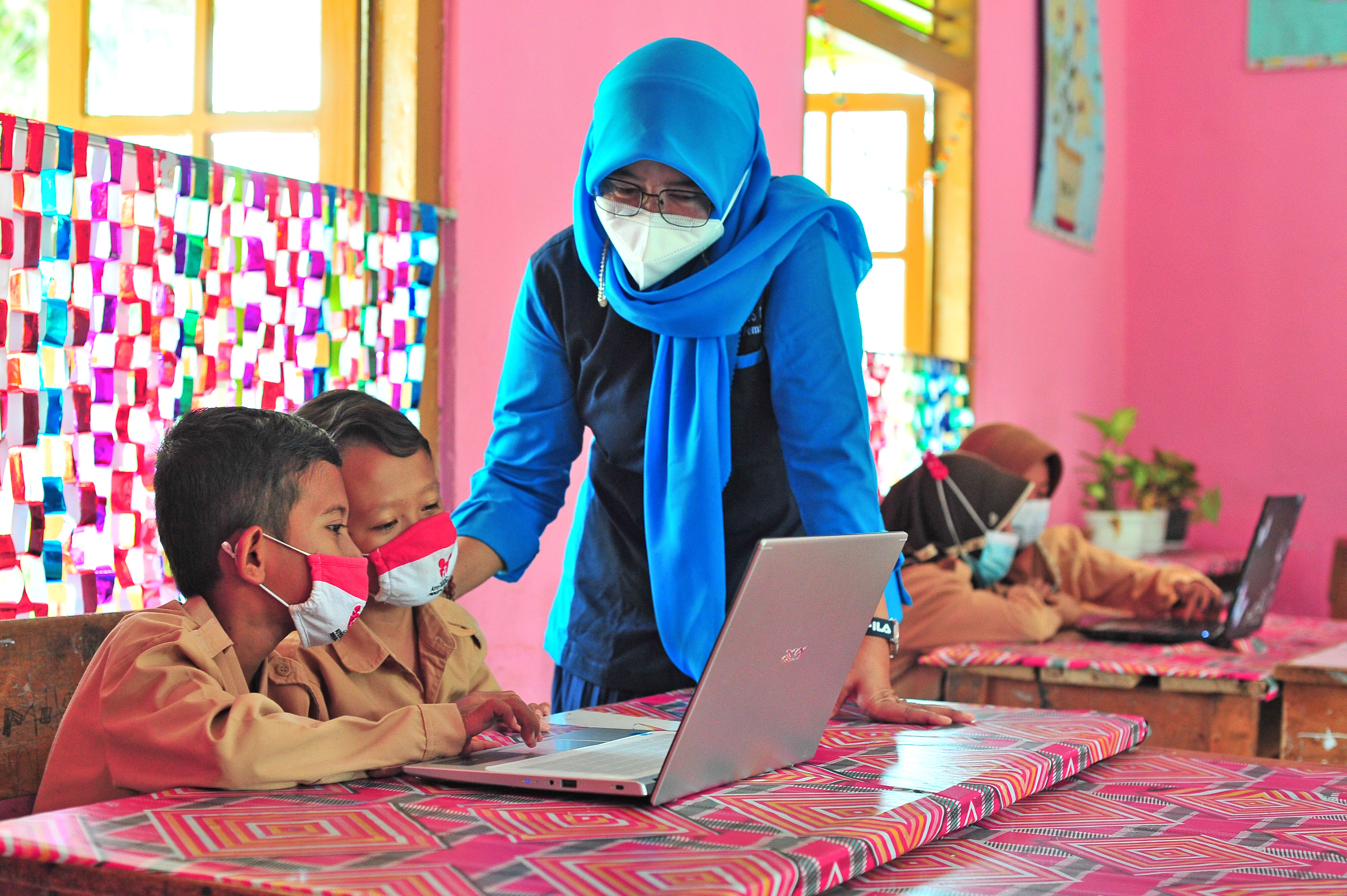 Guru mendampingi siswa menggunakan layanan internet gratis dari Kominfo di SDN 51 Simpang Kubu Kandang, Pemayung, Batanghari, Jambi.