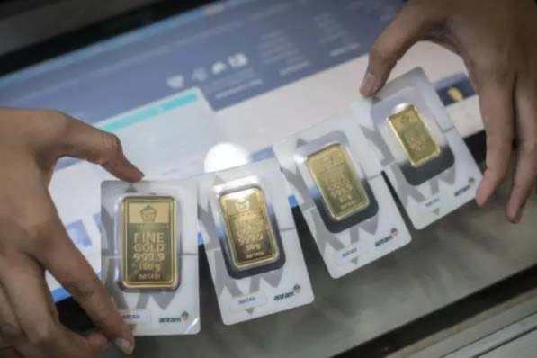 Karyawan menunjukkan imitasi emas batangan Antam di Butik Emas, Jakarta, Selasa (3/3/2020).