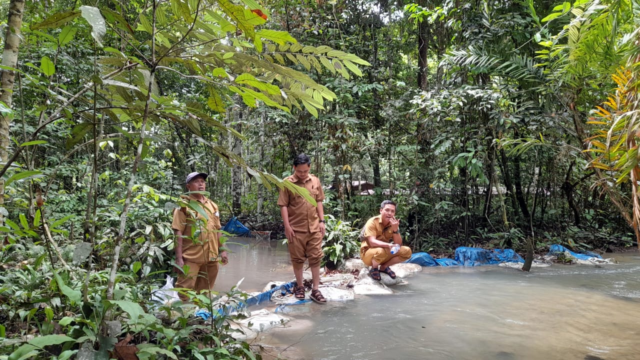 Petugas sedang memeriksa aliran sungai.