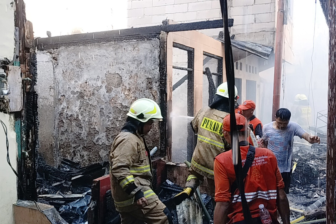 Petugas berusahas memadamkan kebakaran yang terjadi di permukiman padat di Kwitang, Jakarta, Senin (18/12).