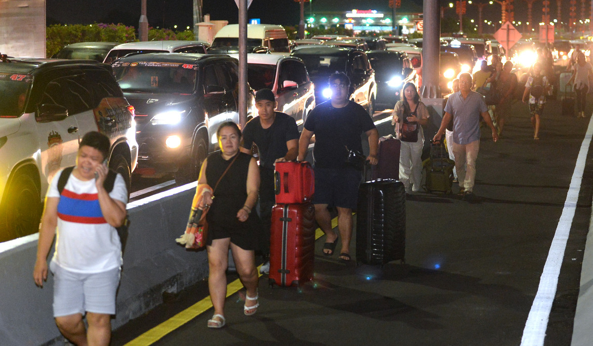 Calon penumpang pesawat berjalan di Jalan Tol Bali Mandara setelah terjebak kemacetan saat menuju ke Bandara I Gusti Ngurah Rai.