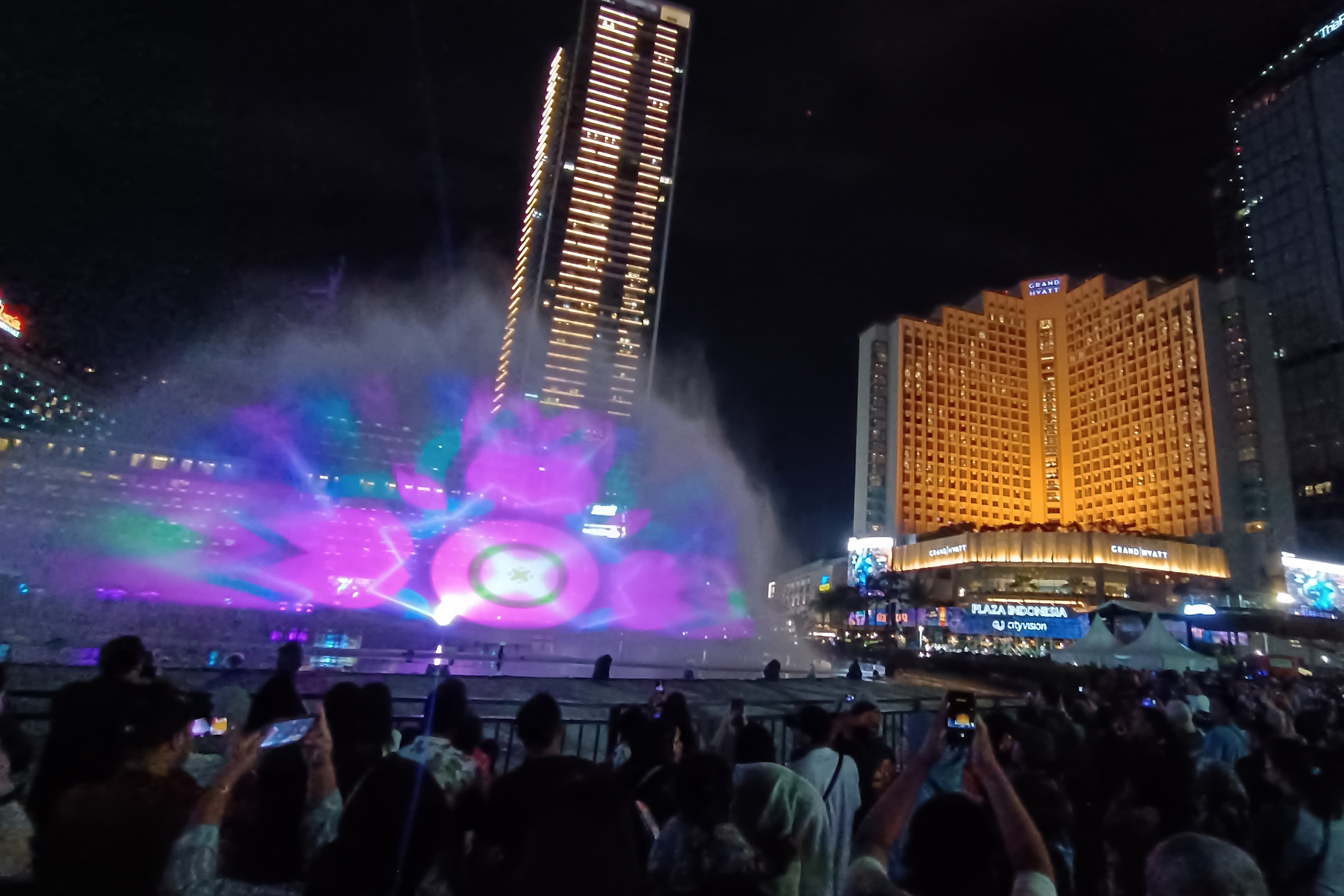 Warga melihat watermist pada perayaan pergantian malam tahun baru di sekitar Bundaran HI