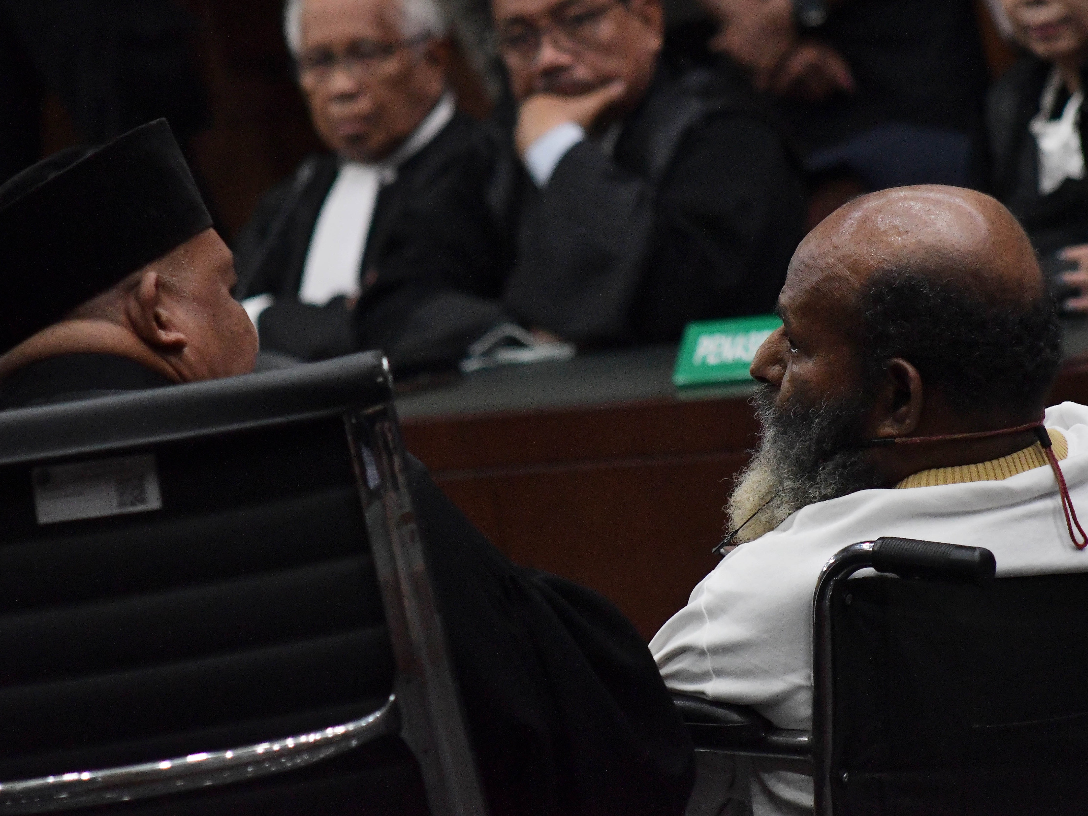 Lukas Enembe (kanan) berbincang dengan tim pengacaranya Petrus Balla Pattyona (kiri) saat sidang putusan di Pengadilan Tipikor, Jakarta.