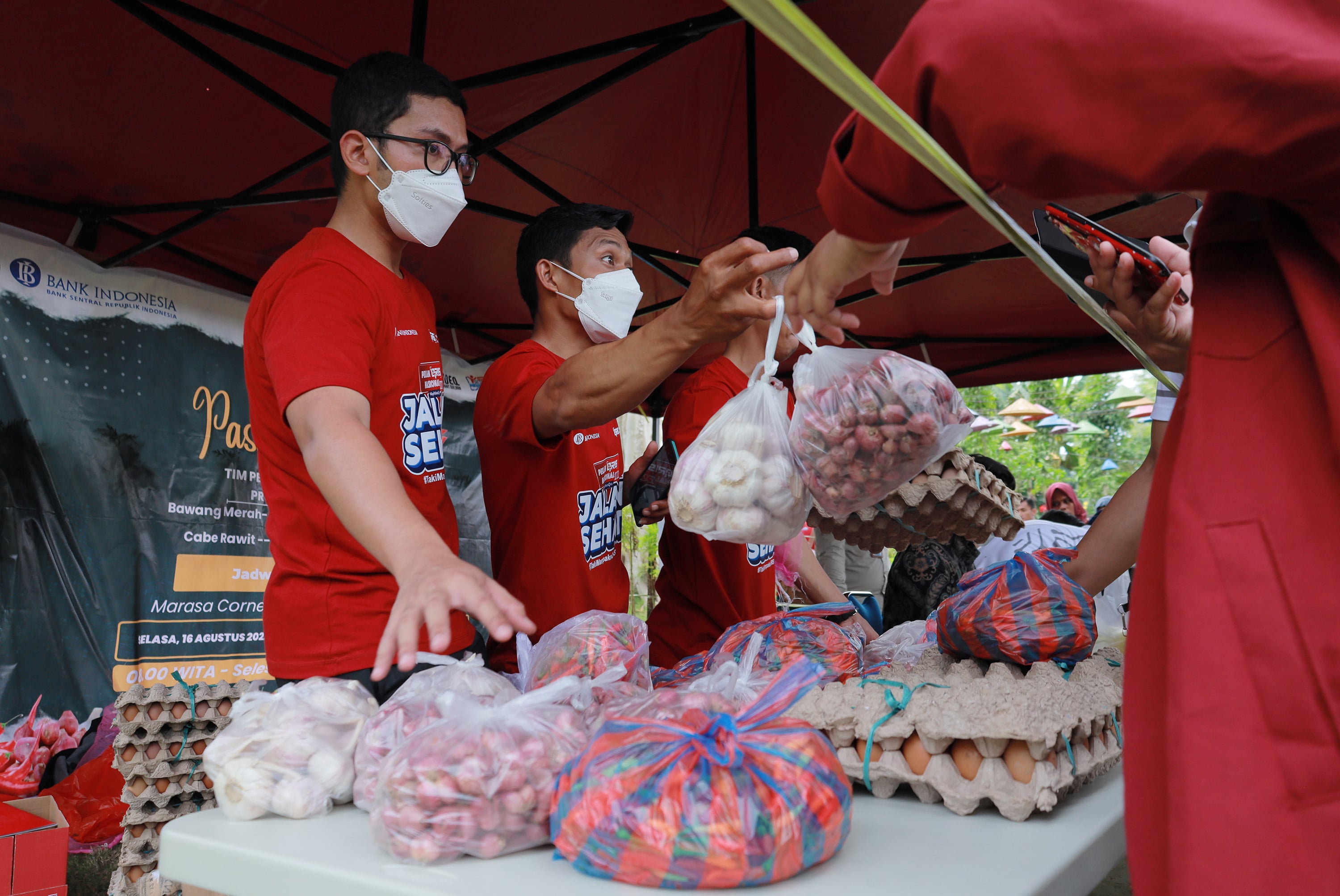Petugas melayani warga yang membeli paket sembako pada pasar murah di halaman kantor Gubernur Sulbar, Mamuju, Sulawesi Barat, Selasa (16/8).