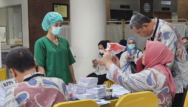 Anggota Panitia PPS menunjukkan surat suara yang utuh ke tenaga medis yang menggunakan hak pilih di TPPS 