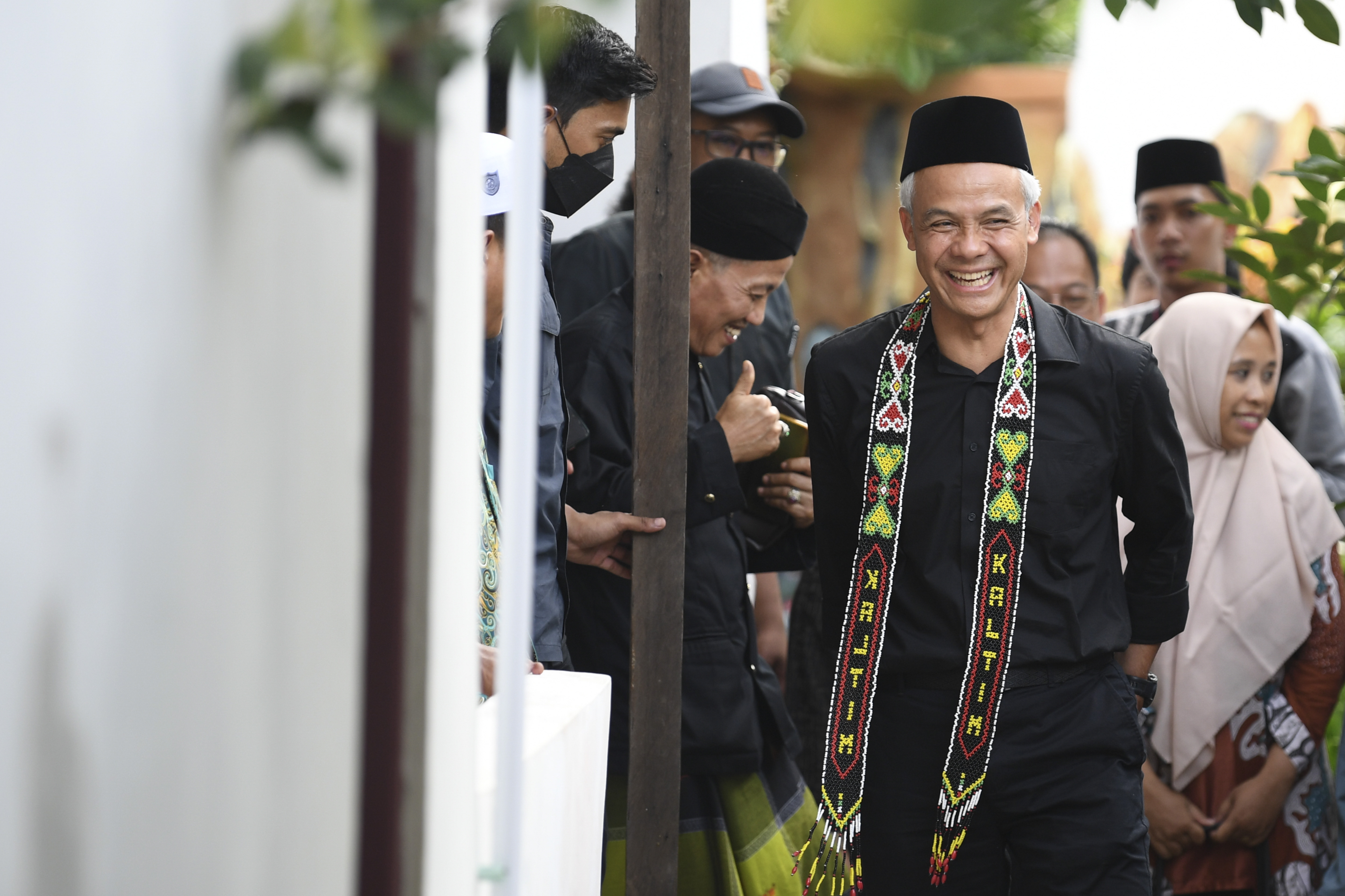 Calon presiden nomor urut 3 Ganjar Pranowo (tengah) berjalan meninggalkan ruangan saat bersilaturahim di Pondok Pesantren Syaichona Cholil,