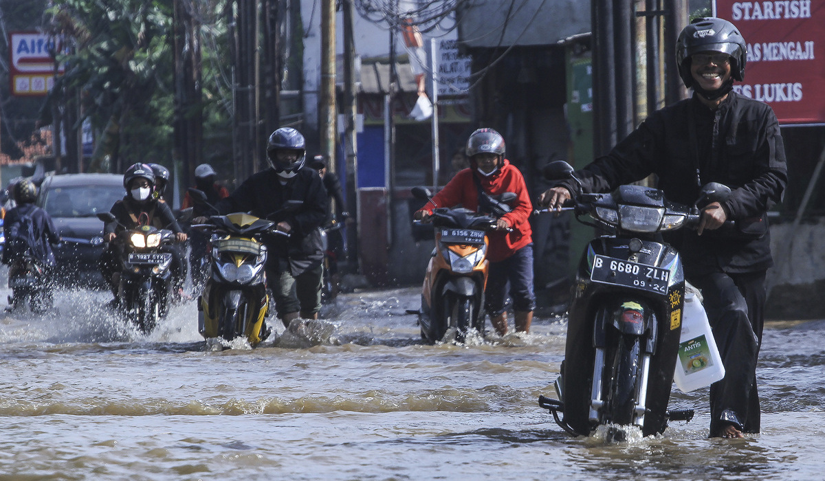 Sejumlah kendaraan mogok saat melintasi banjir di Kawasan Perempatan Mampang, Depok.