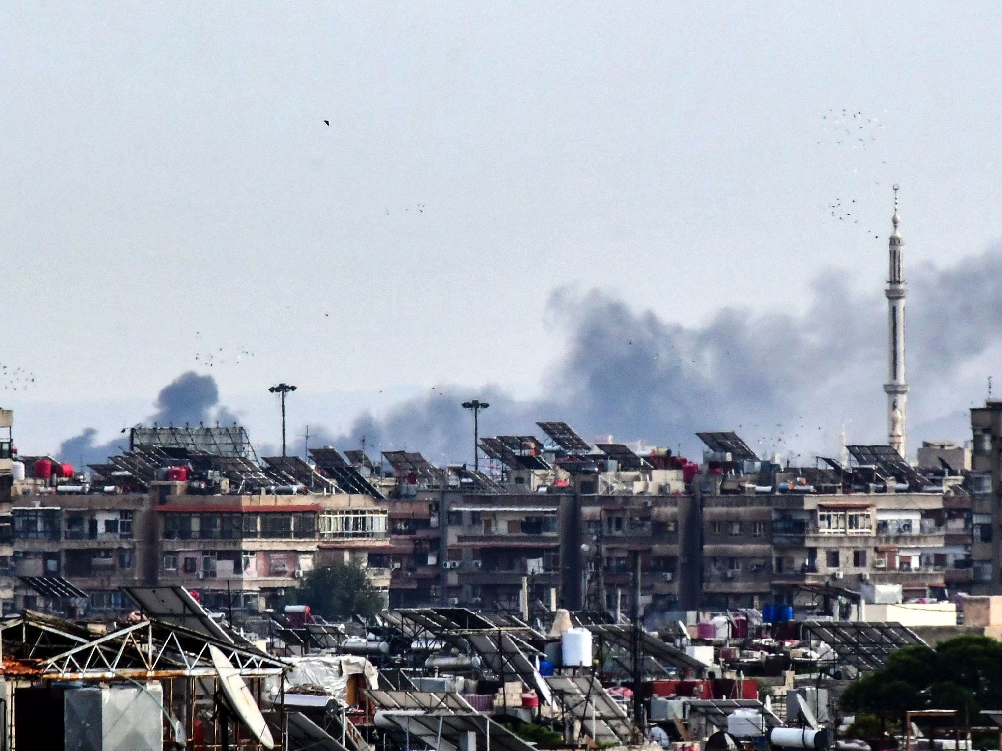 Asap mengepul di atas gedung-gedung setelah serangan Israel di pinggiran Damaskus pada 22 November 2023.