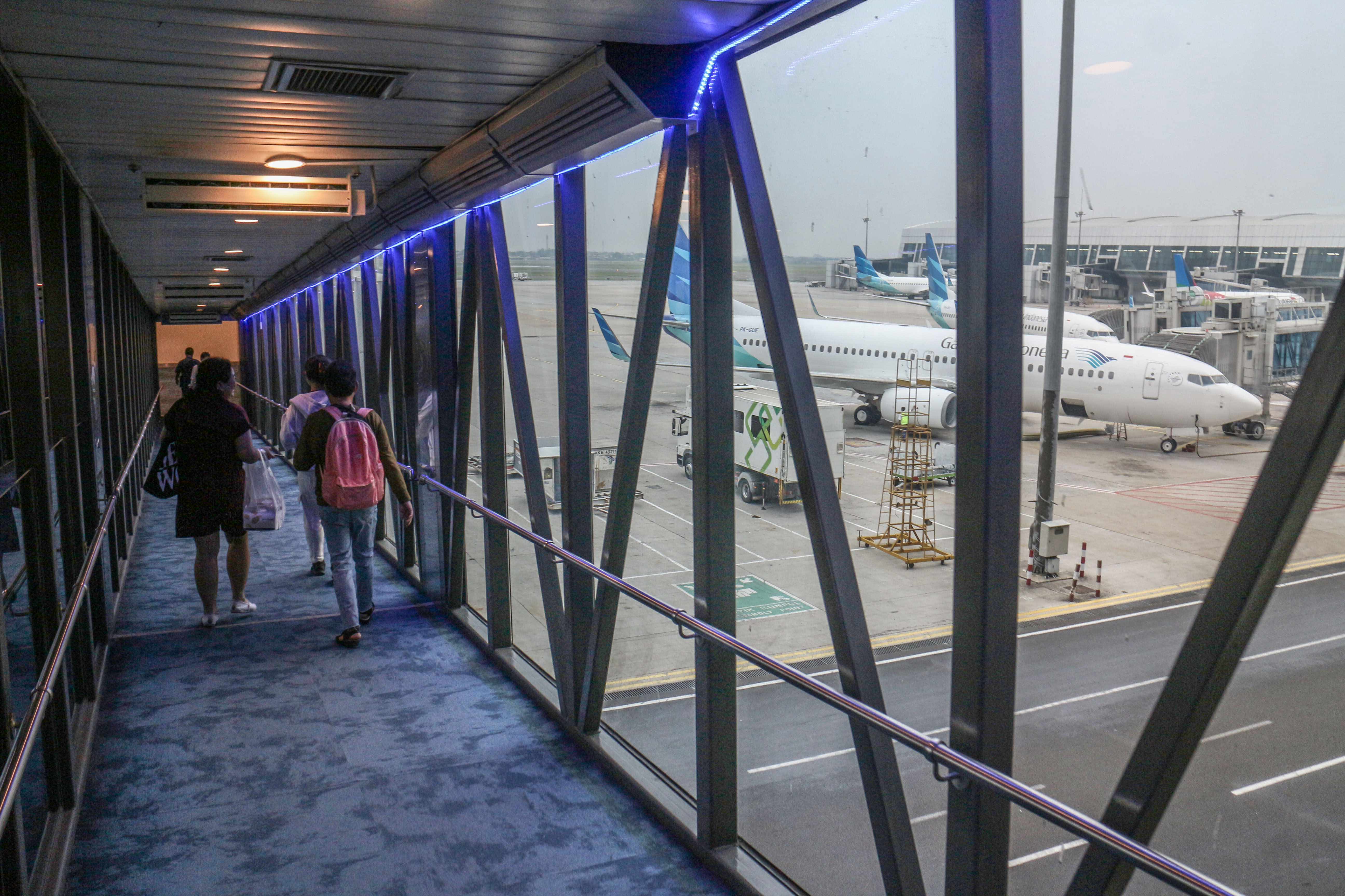 Penumpang melintasi garbarata saat menaiki pesawat di Bandara Soekarno Hatta 