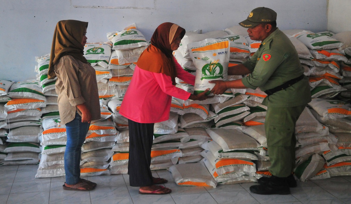 Warga menerima beras saat penyaluran bantuan pangan cadangan beras pemerintah di Desa Mijen, Kaliwungu, Kudus, Jawa Tengah.