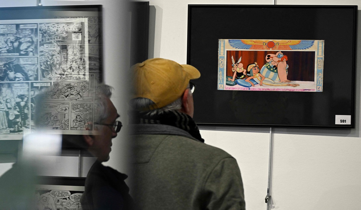 Seorang pengunjung melihat lukisan kover karya Albert Uderzo, Asterix and Cleopatra, di rumah lelang Millon.