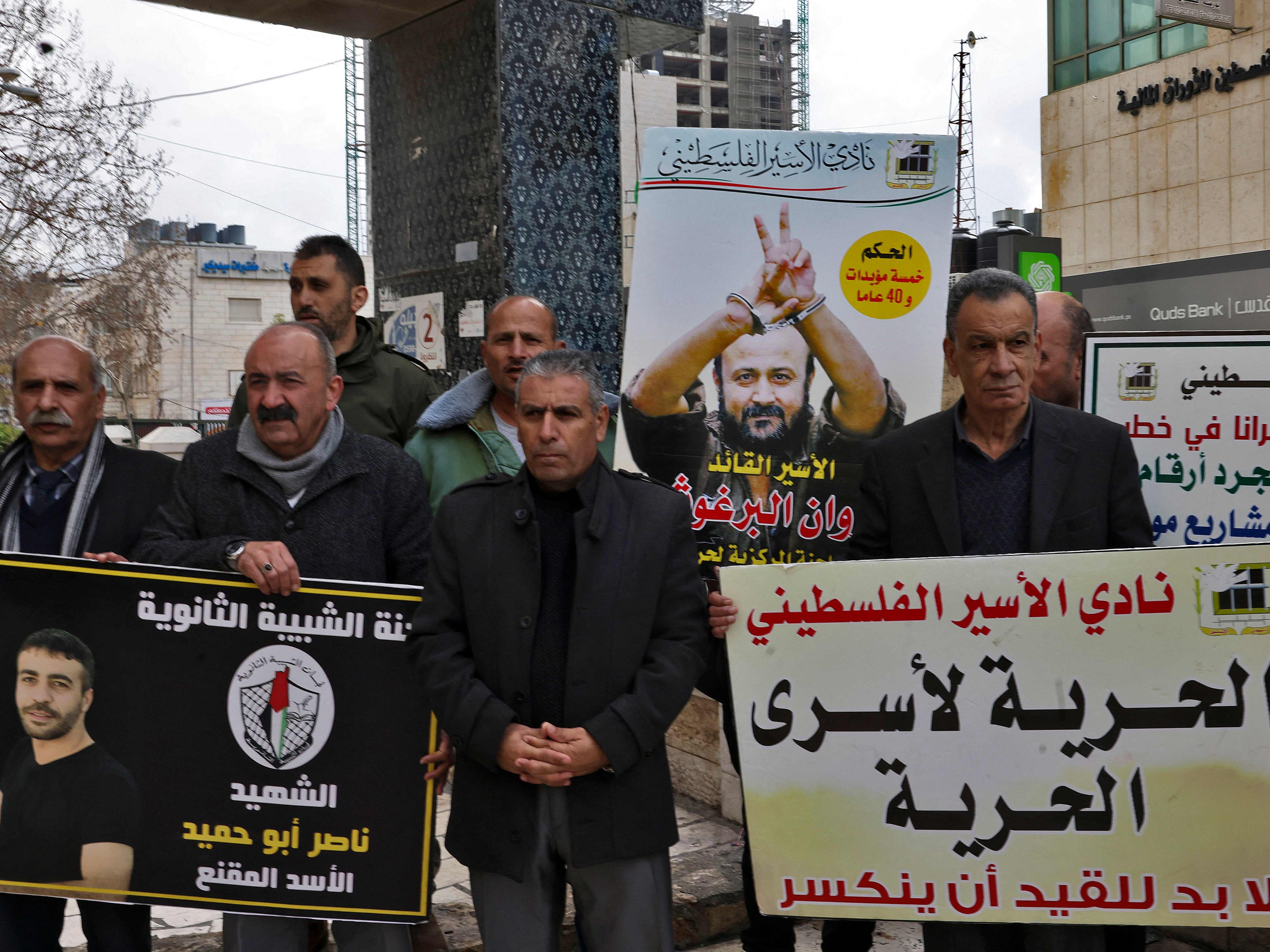 Para pengunjuk rasa memegang spanduk dan gambar narapidana selama demonstrasi solidaritas dengan tahanan Palestina yang ditahan Israel.