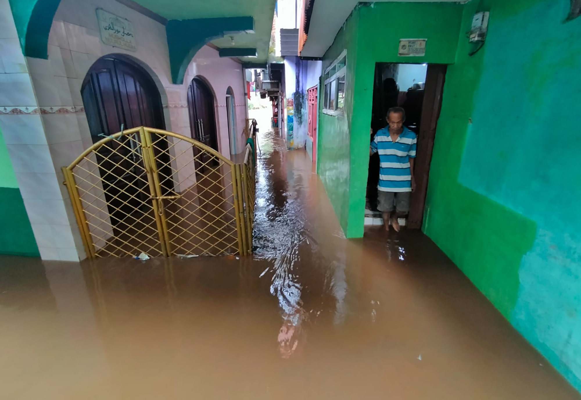 Warga beraktivitas di tengah banjir yang merendam pemukiman padat penduduk di Kampung Melayu, Jakarta.