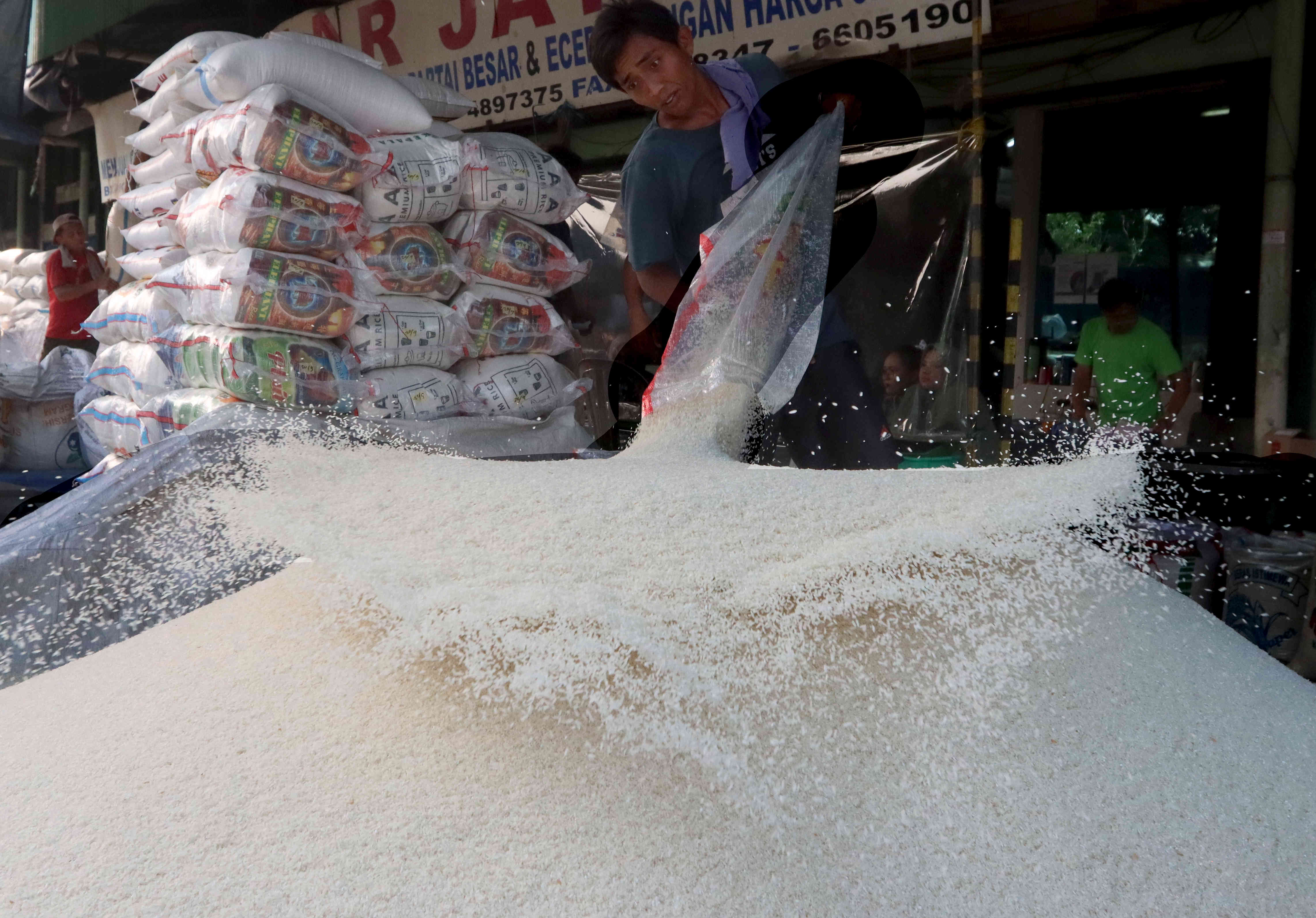 Pekerja tengah menata beras karungan di Pasar Induk Beras Cipinang, Jakarta.