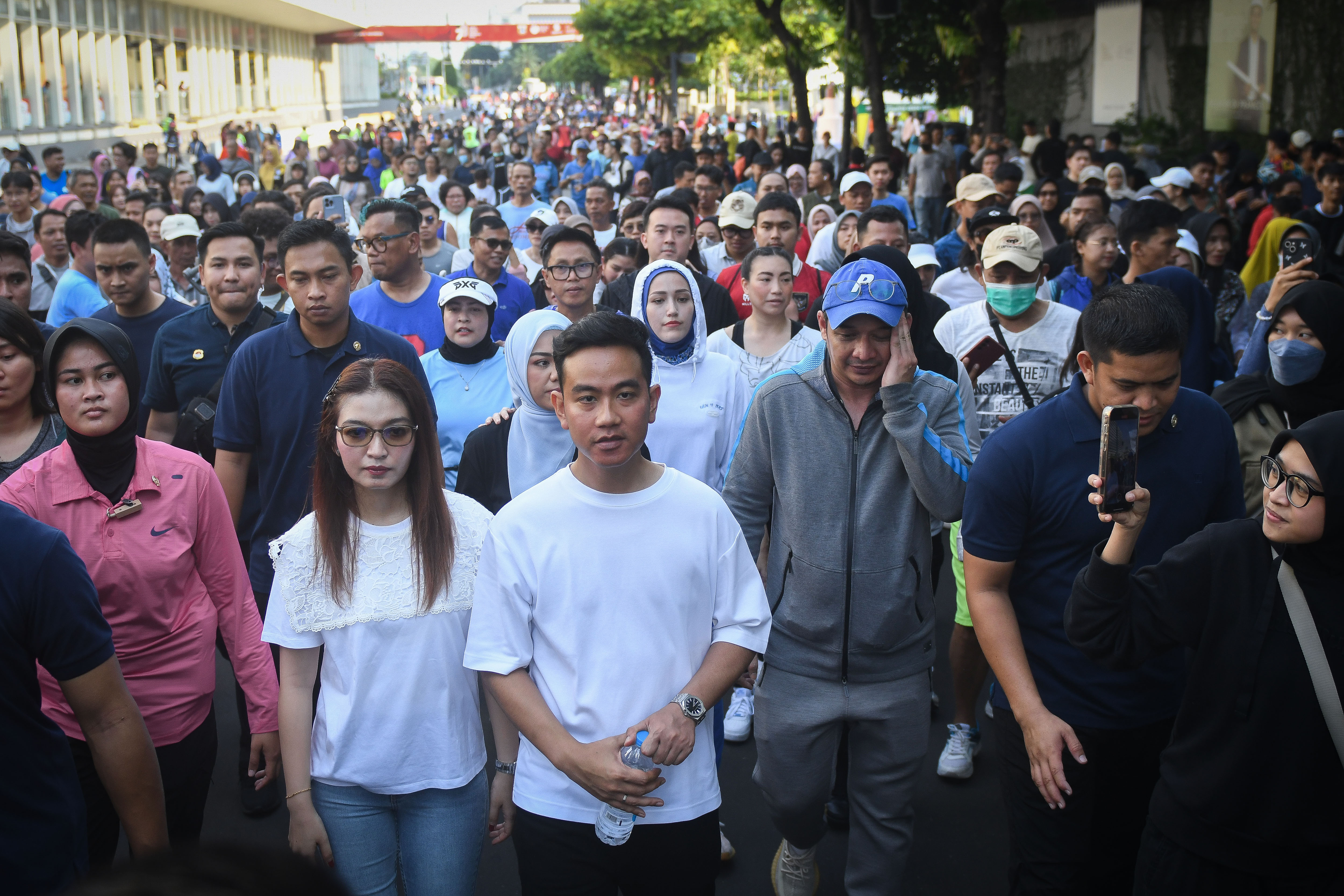 Gibran Rakabuming Raka (tengah) berjalan kaki di area hari bebas kendaraan bermotor (HBKB) Jalan MH Thamrin, Jakarta, Minggu (3/12/2023).
