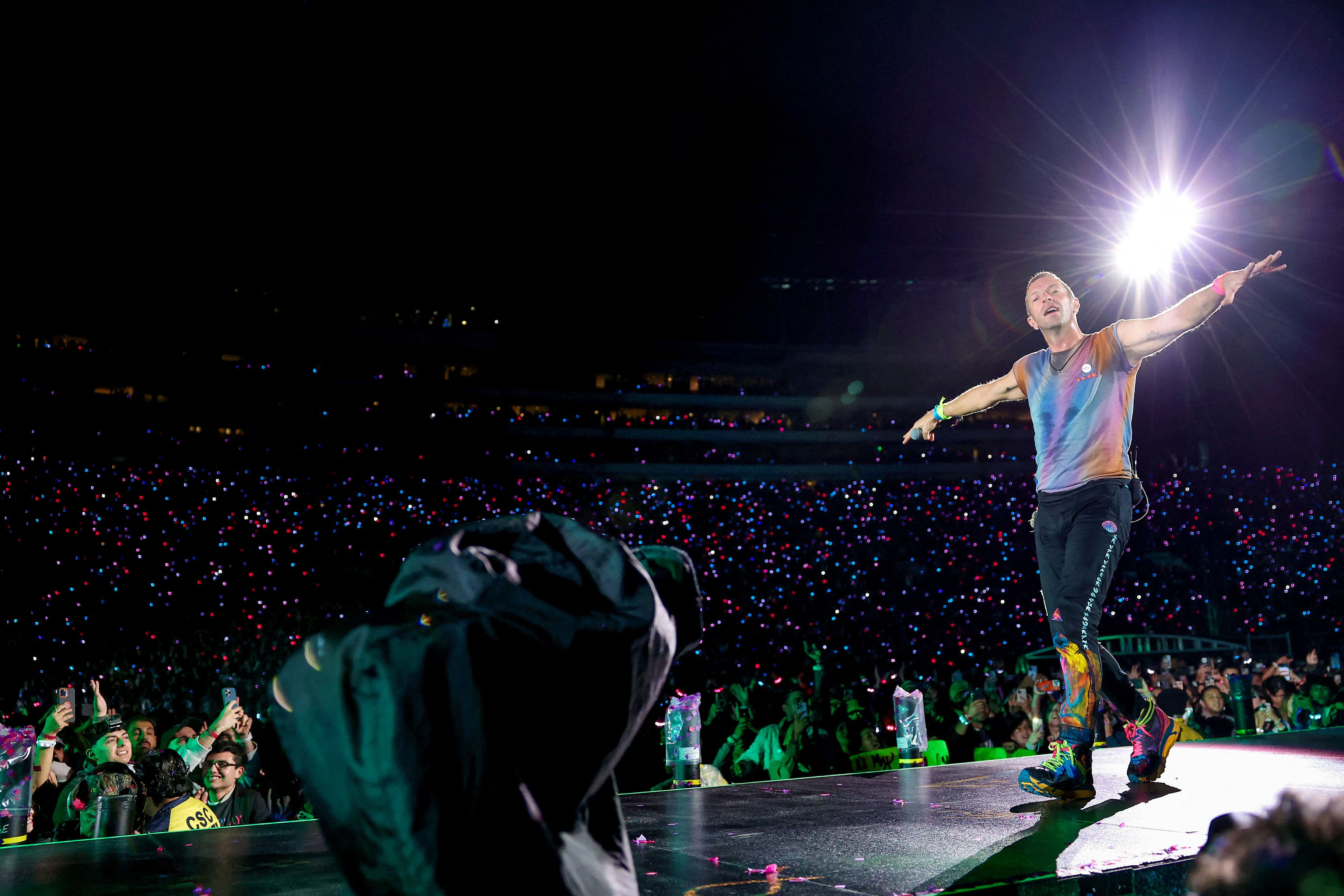 Aksi panggung vokalis Chris Martin dari grup musik Coldplay. Banyak konsumen Indonesia pergi ke luar negeri untuk menonton konser musik. 