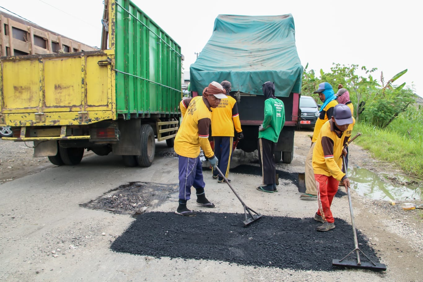Pekerja memperbaiki jalan di Kabupaten Lamongan, Jawa Timur, Kamis (13/4/2023).