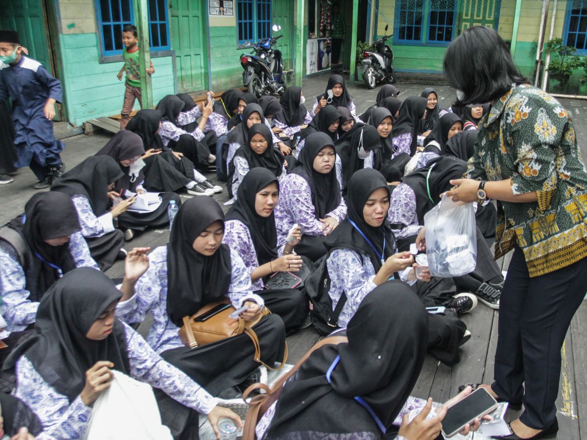 Petugas puskesmas membagikan tablet tambah darah gratis kepada siswa remaja putri di Madrasah Aliyah Darul Ulum, Palangka Raya, Kalteng.