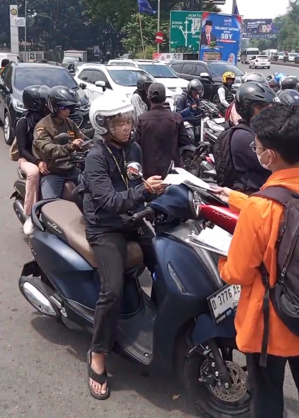 Mahasiswa dari salah satu kampus di Bandung membagikan selebaran mengajak warga menolak politik dinasti