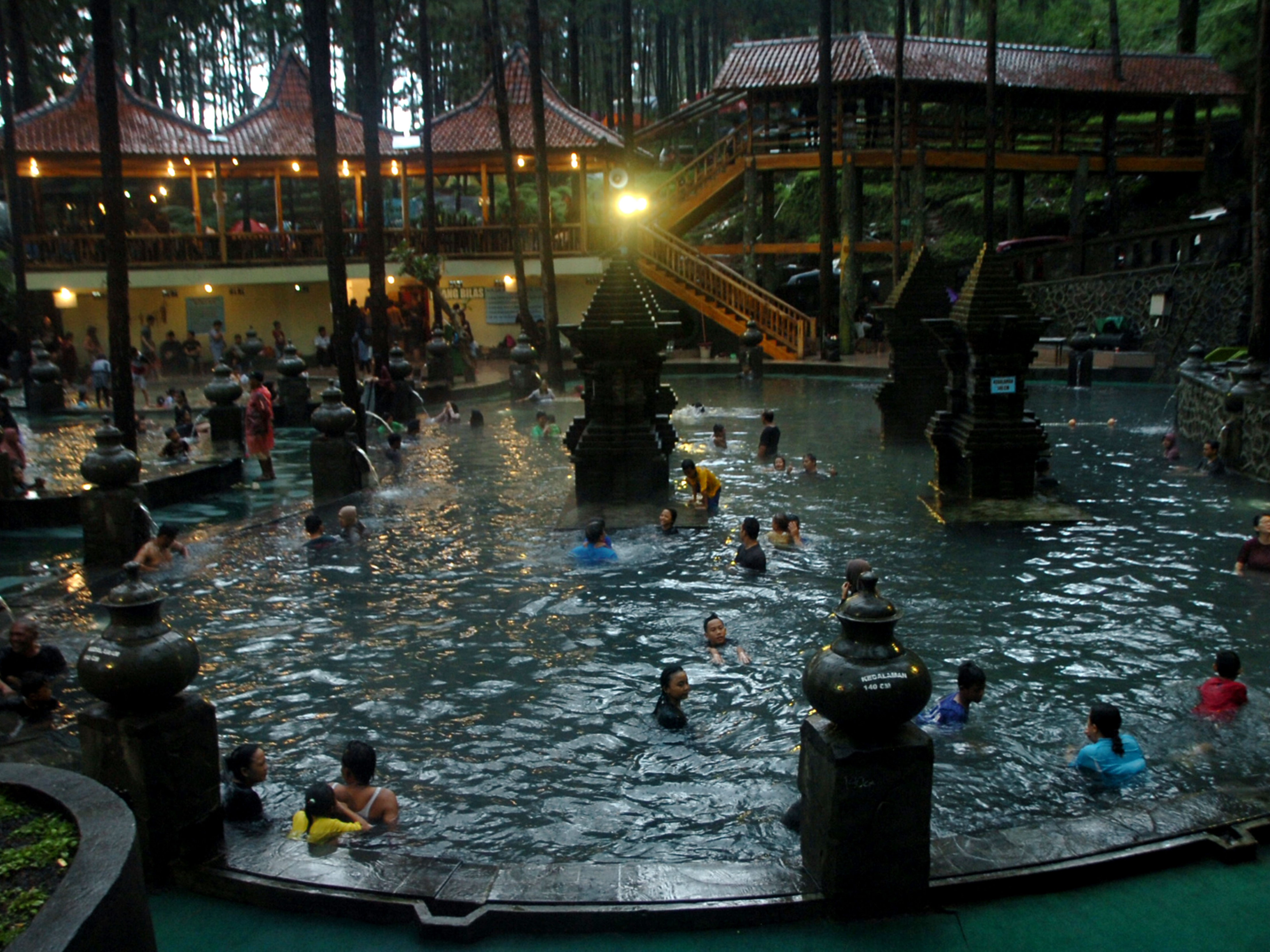 Wisatawan berenang di kolam pemandian kawasan hutan pinus di wisata alam Guci Forest, Guci, Kabupaten Tegal, Jawa Tengah, Sabtu (30/12).