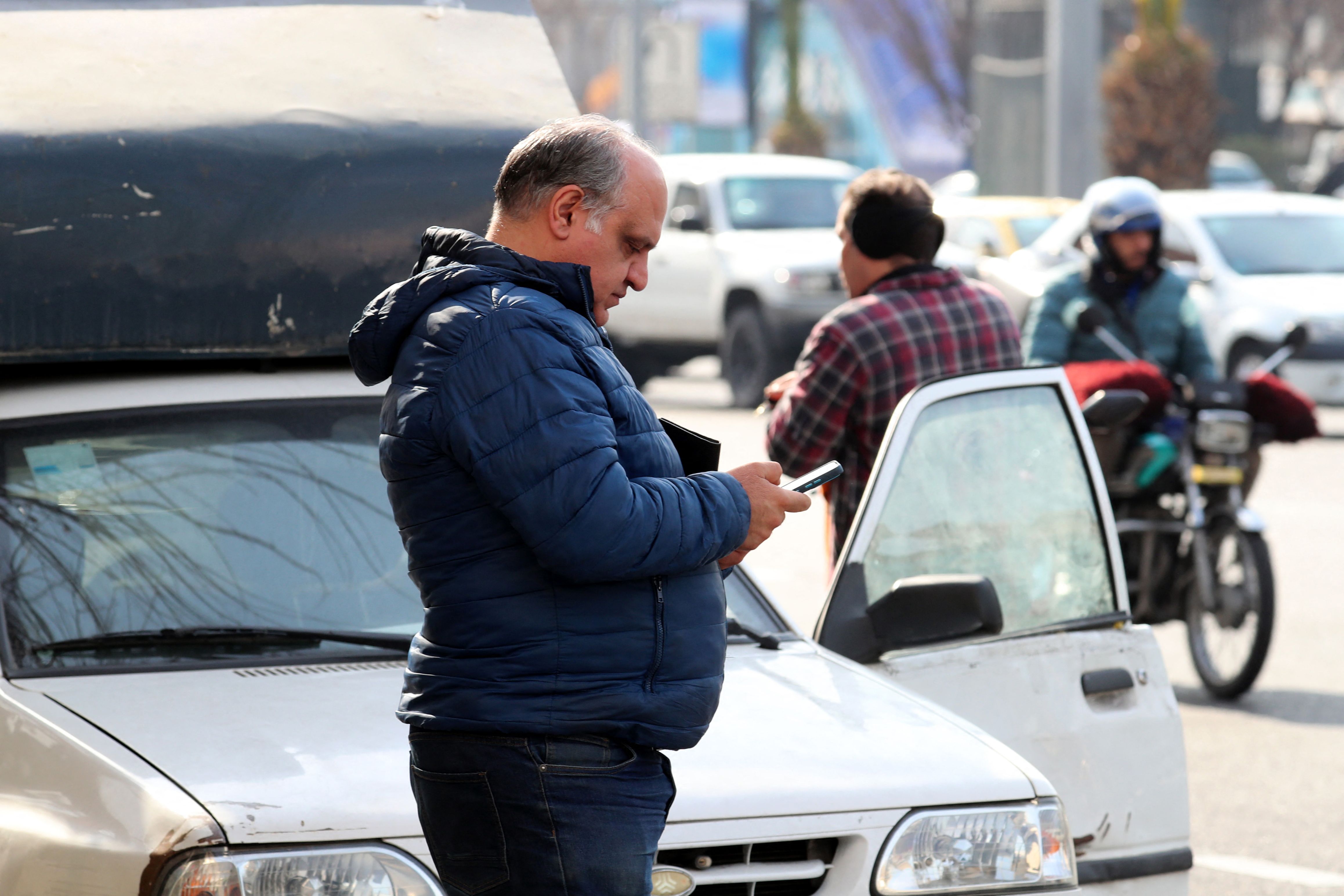 Warga Iran mengecek ponselnya pasca serangan balasan Pakistan
