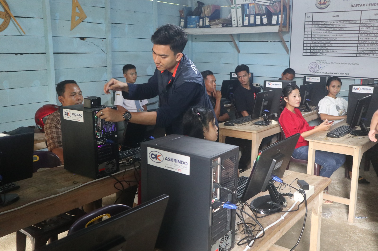 Seorang teknisi tengah memperbaiki komputer untuk pendidikan di daerah 3T.